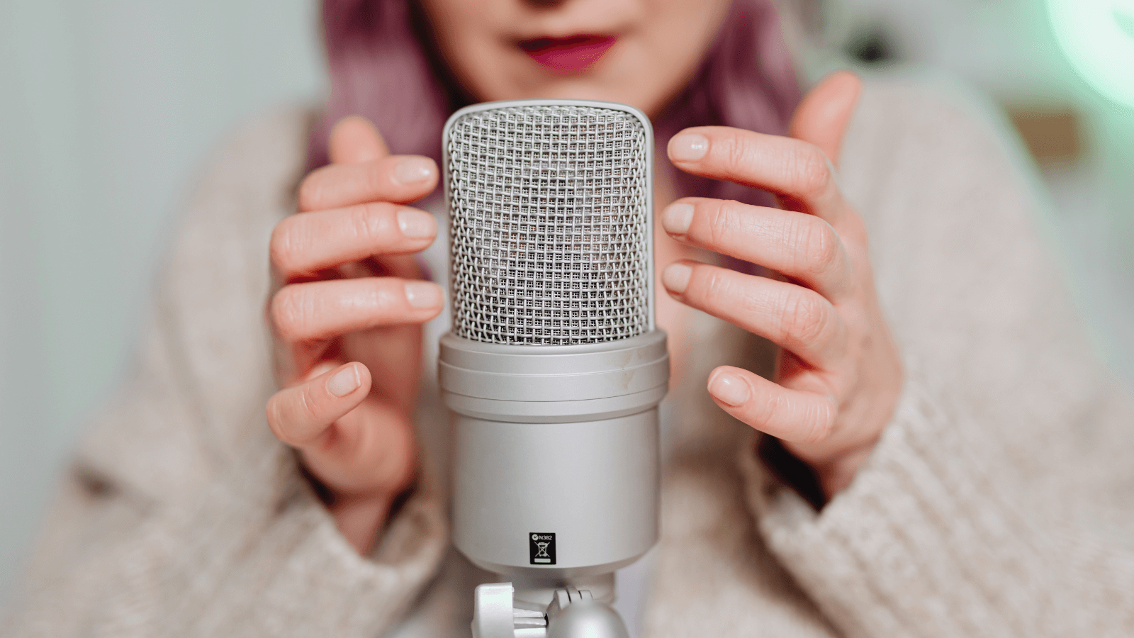 A woman clicking her nails against a microphone