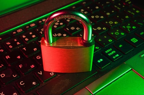 a gold padlock resting on top of a black keyboard.