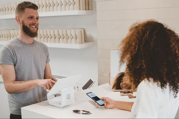 A cashier checks out a customer at a candle store