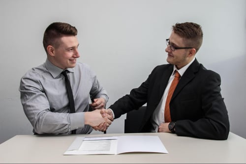 Two people in business attire shaking hands