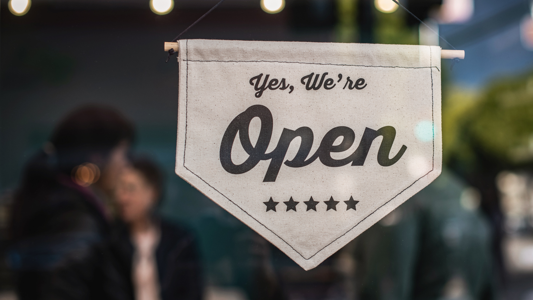 A banner in a window that reads "yes we're open"