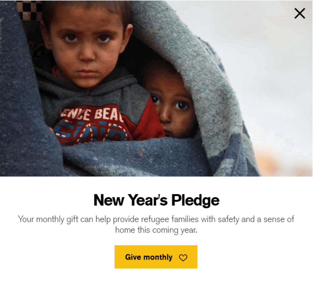 International Rescue Committee's homepage, featuring a photo of two small refugee children wrapped in a blanket