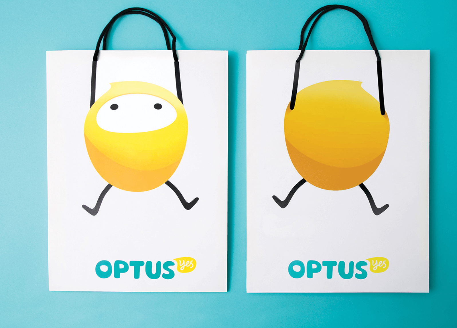 Two shopping bags with the Optus mascot printed so its arms line up with the handles. One side is the front of the mascot, the other side is the back. 