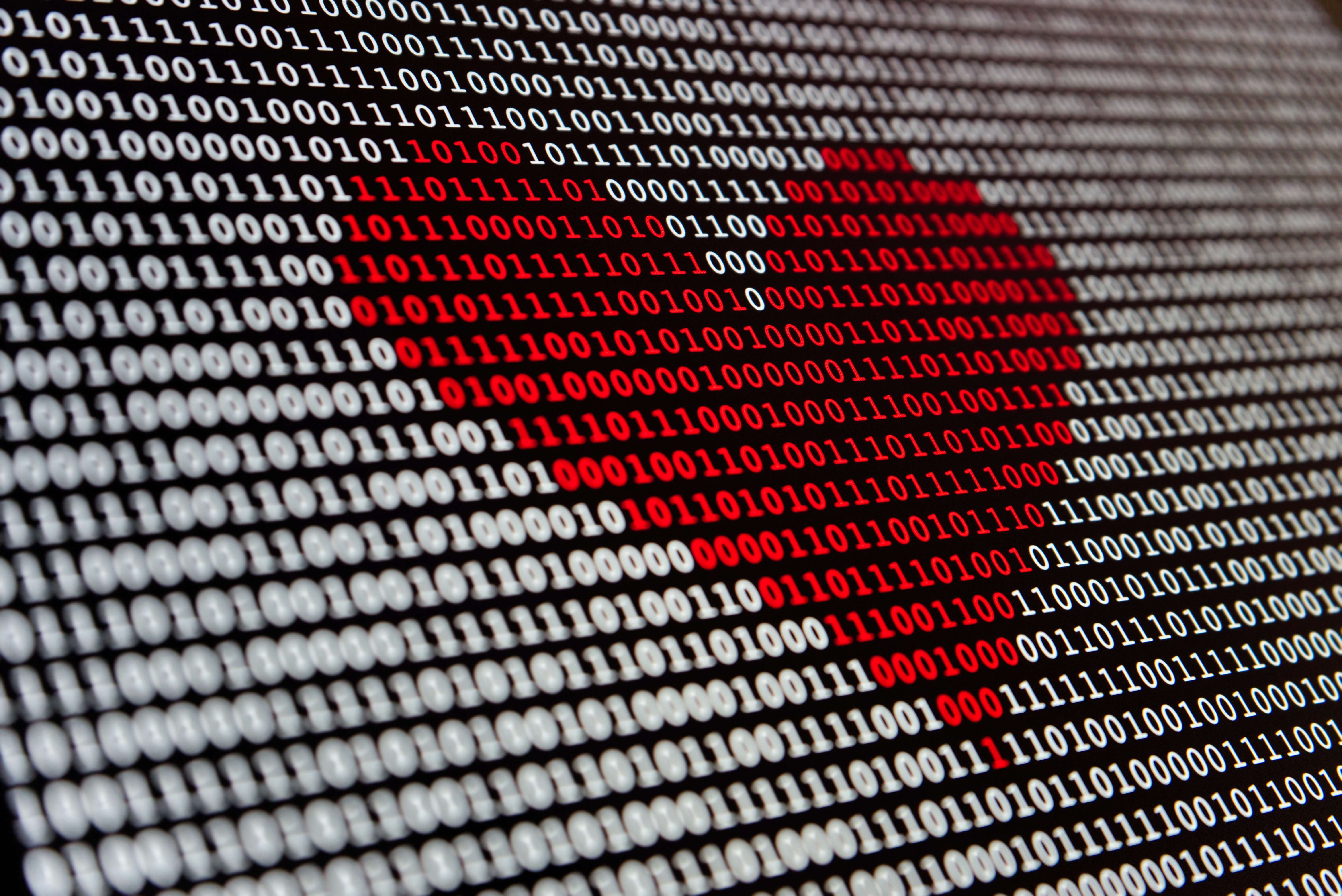 Binary code in a red heart against a white background