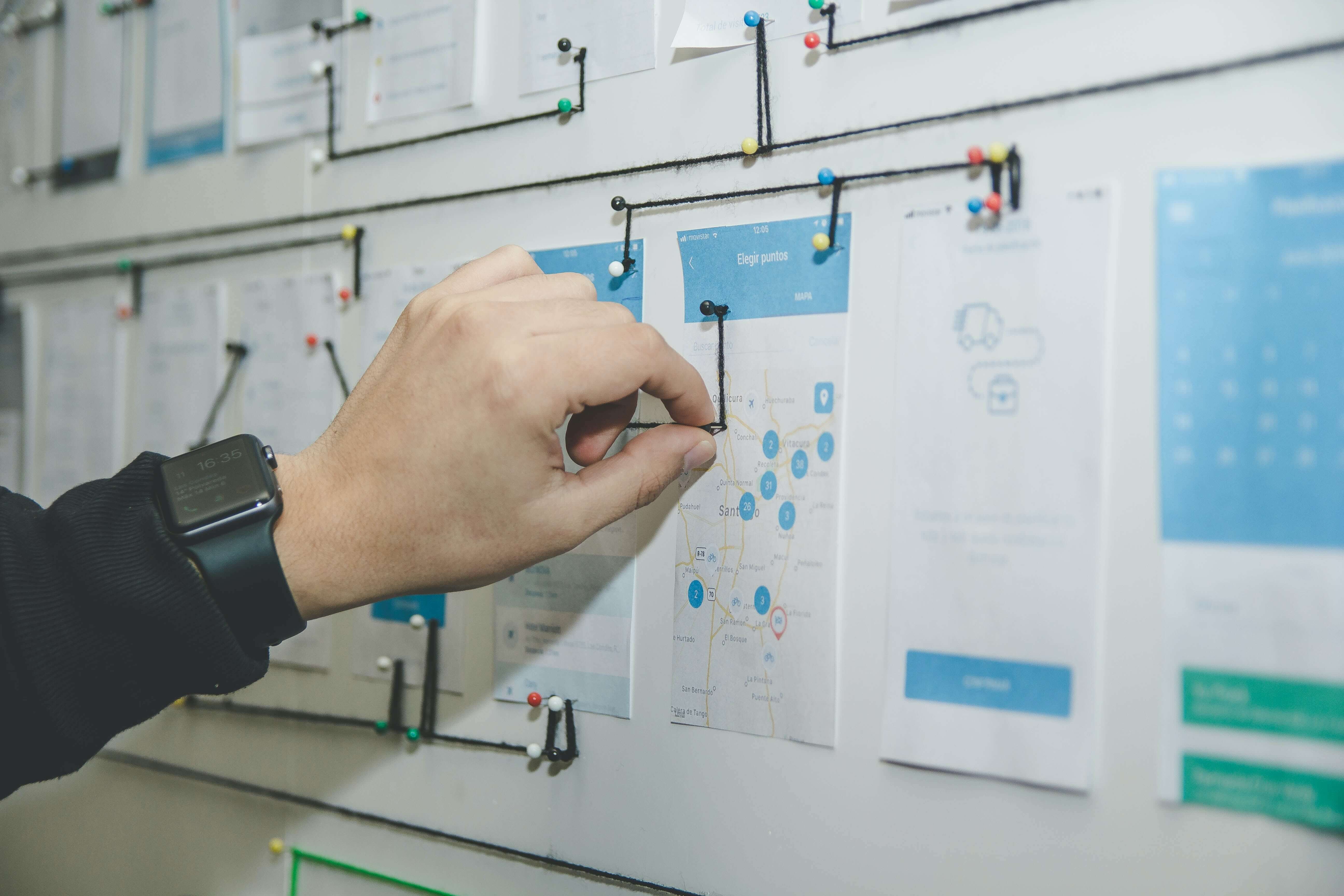 A person making a UX design map on a bulletin board