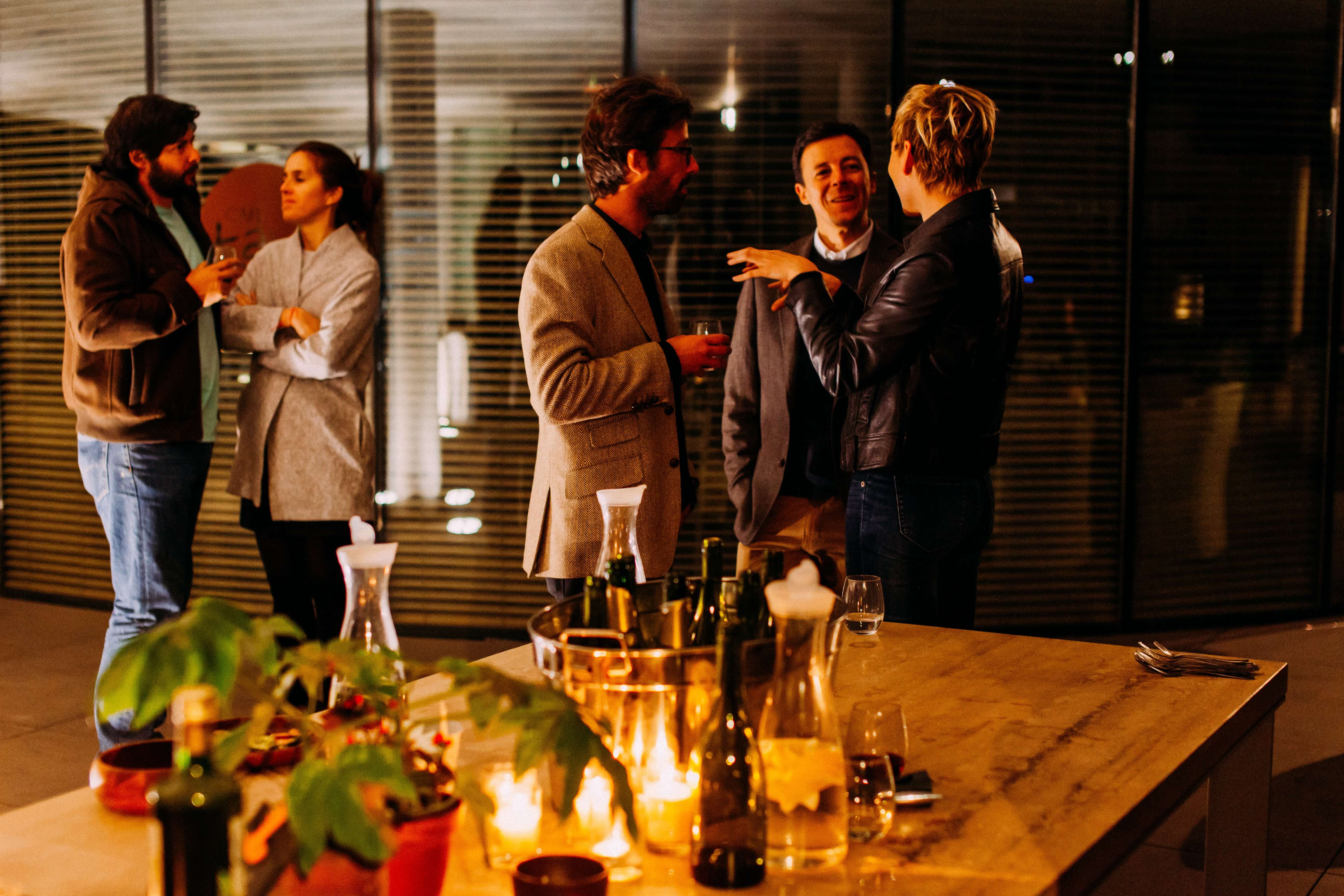 Five people in business casual clothing mingling at an event