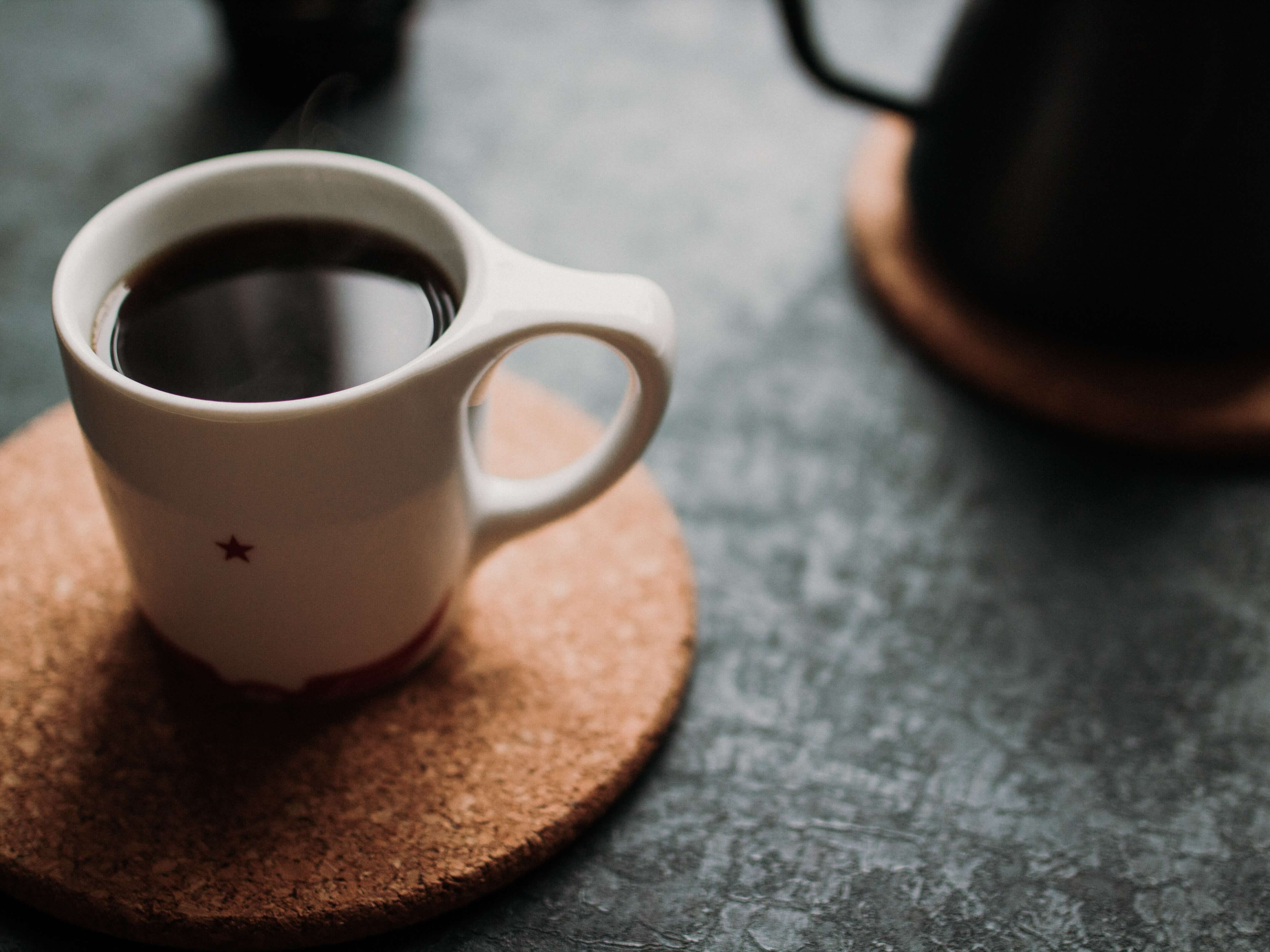 An espresso cup sitting on a coaster