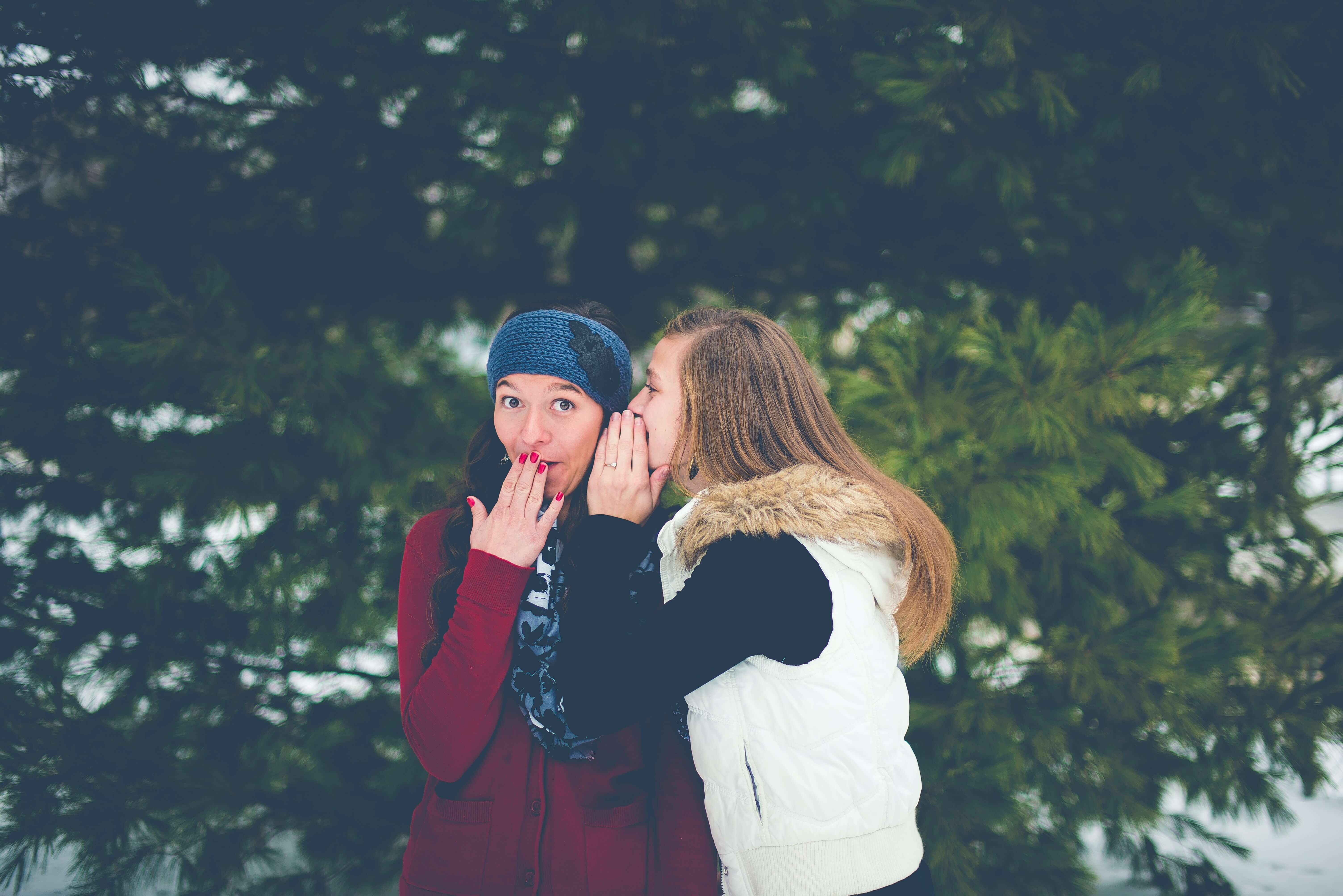 One girl whispering to another