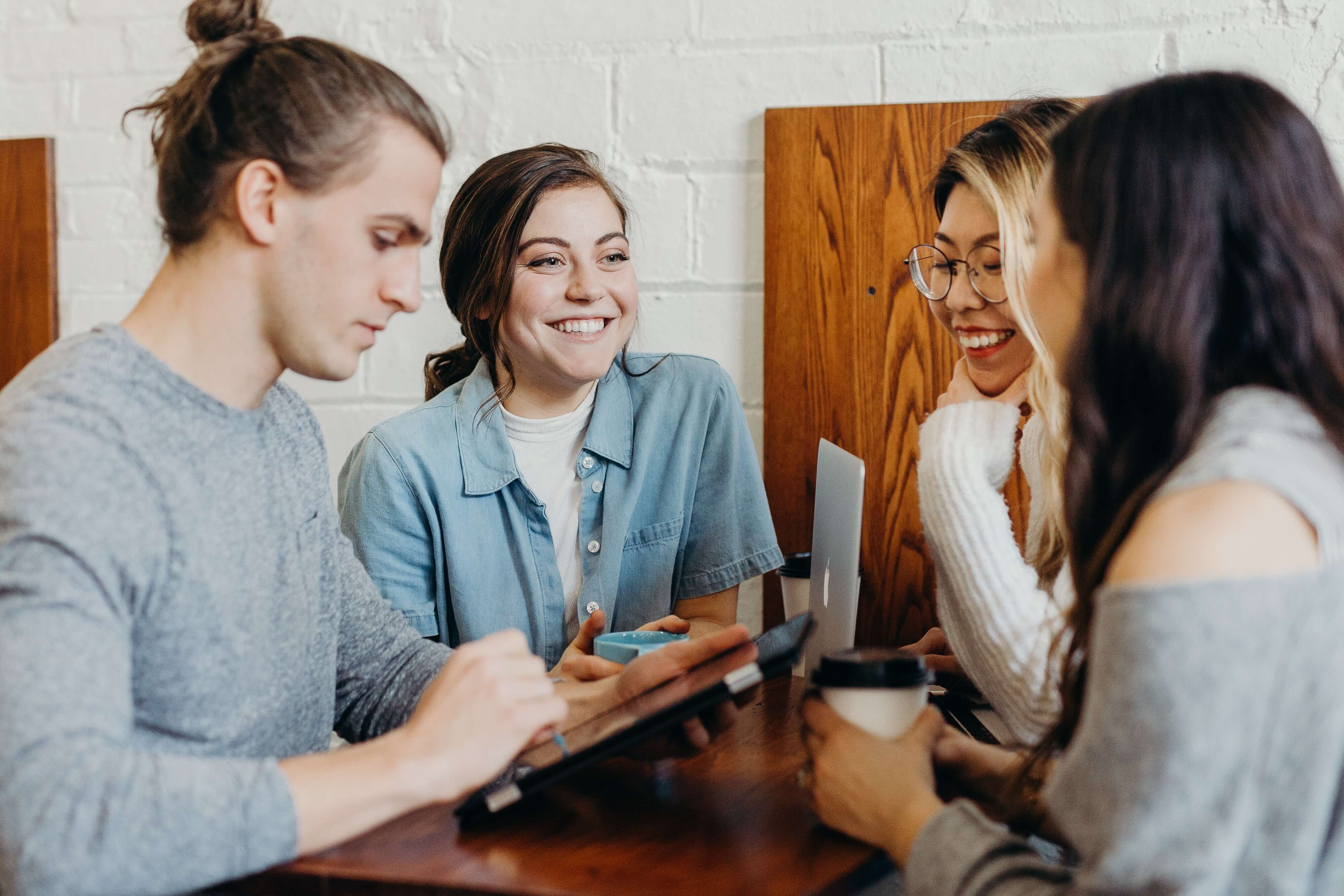 A group of young people discussing over a computer