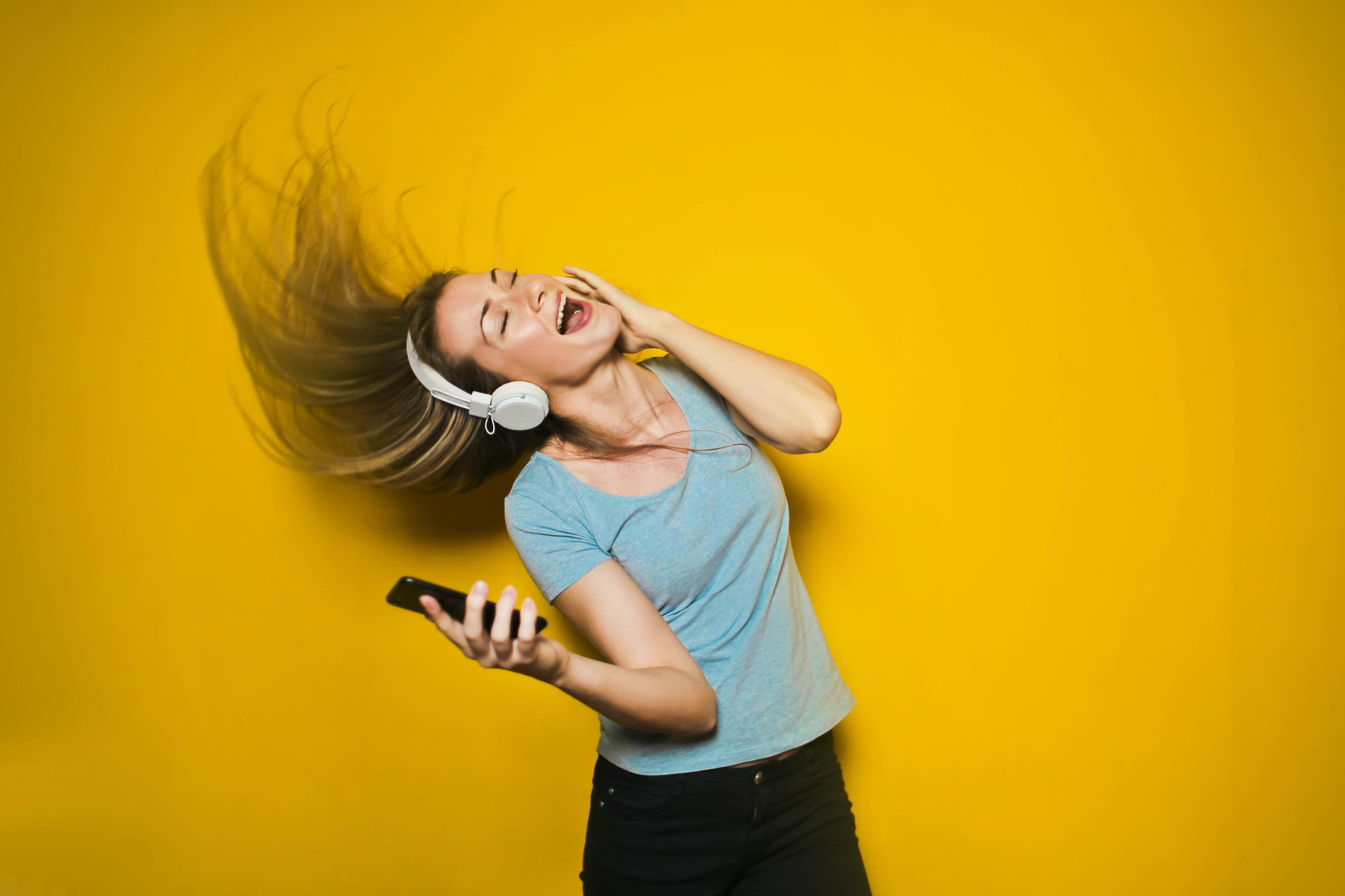 A white woman dancing with headphones on