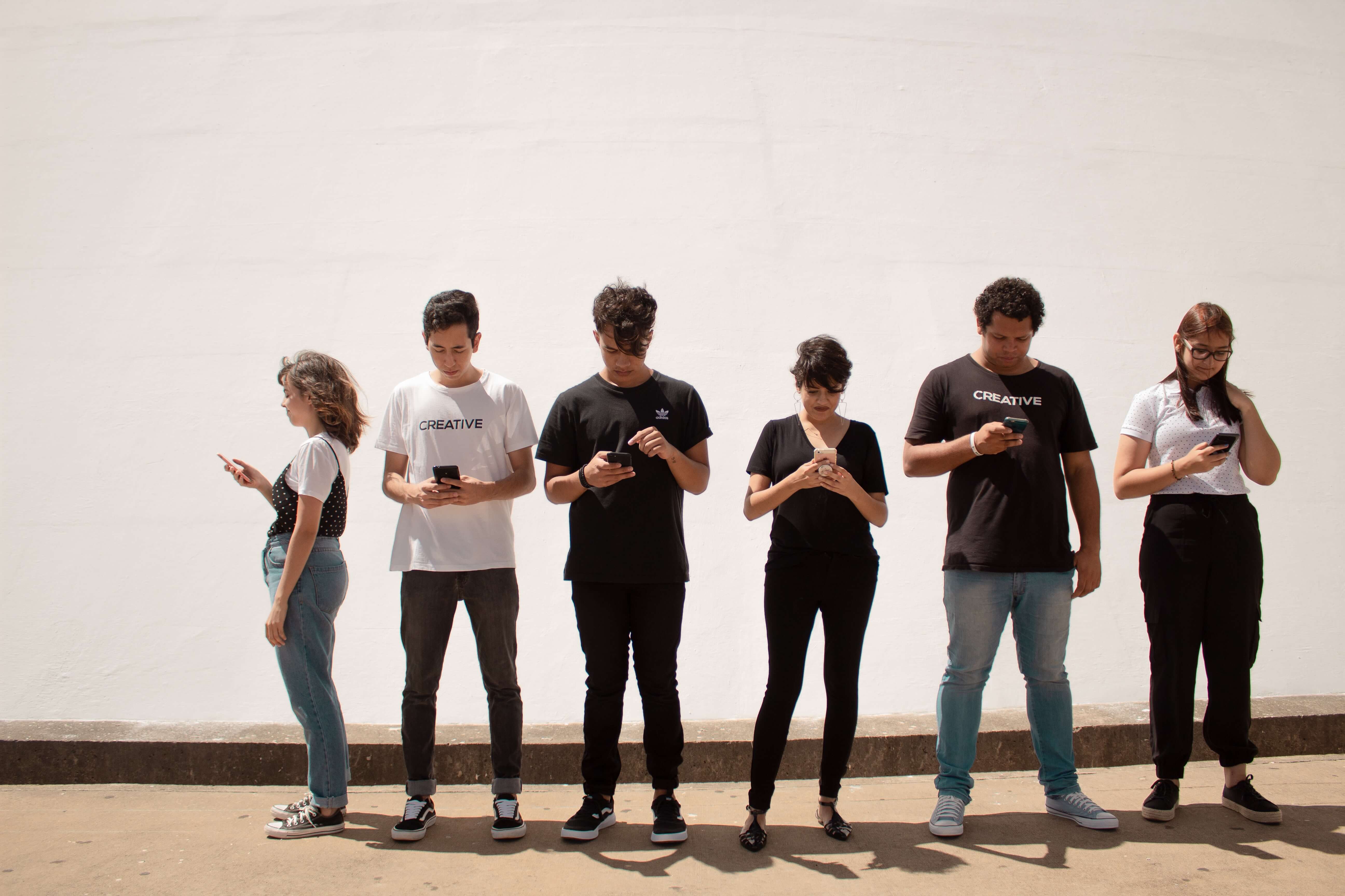 Six teenagers looking at their phones
