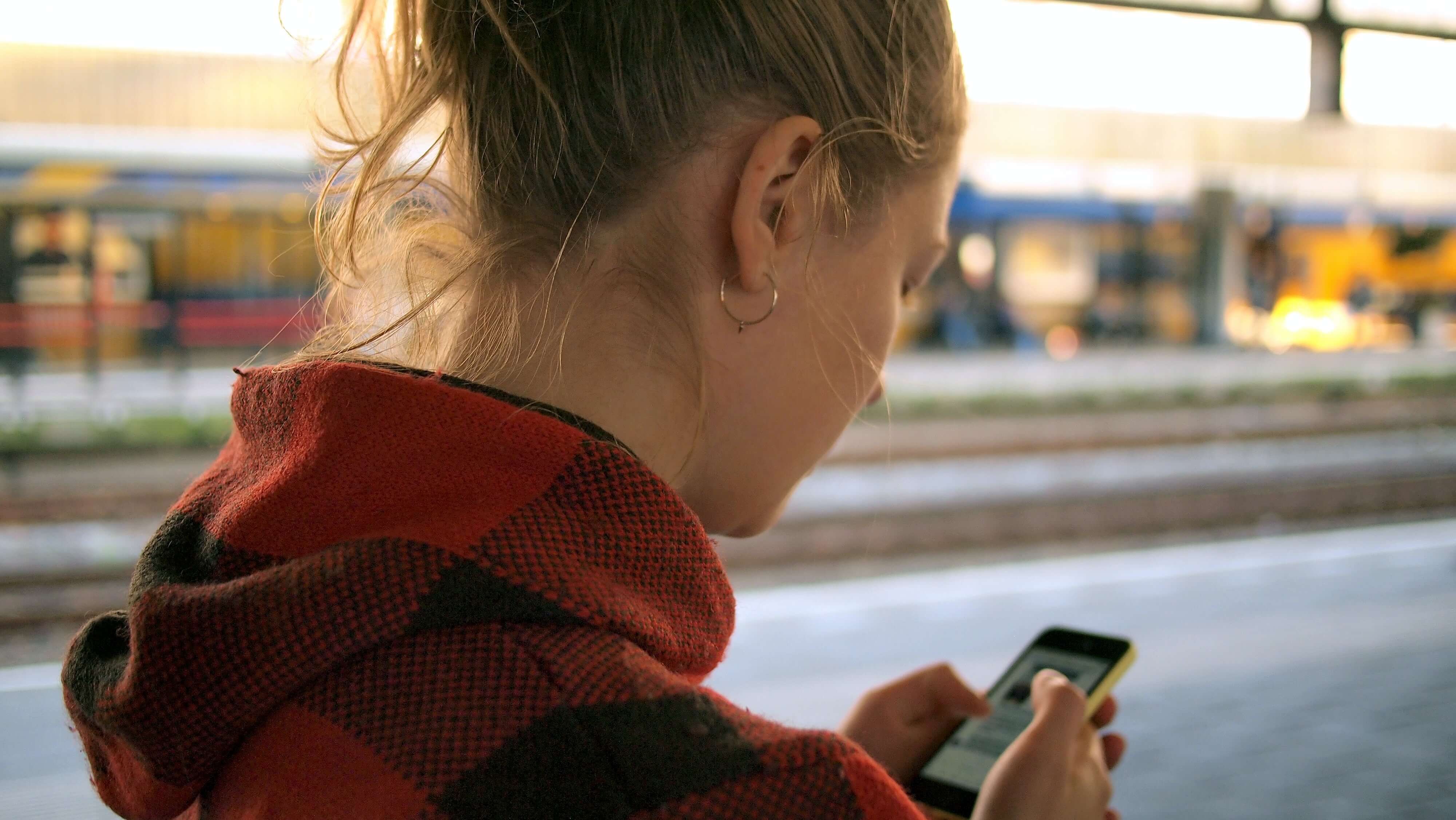 A blonde woman using a smartphone