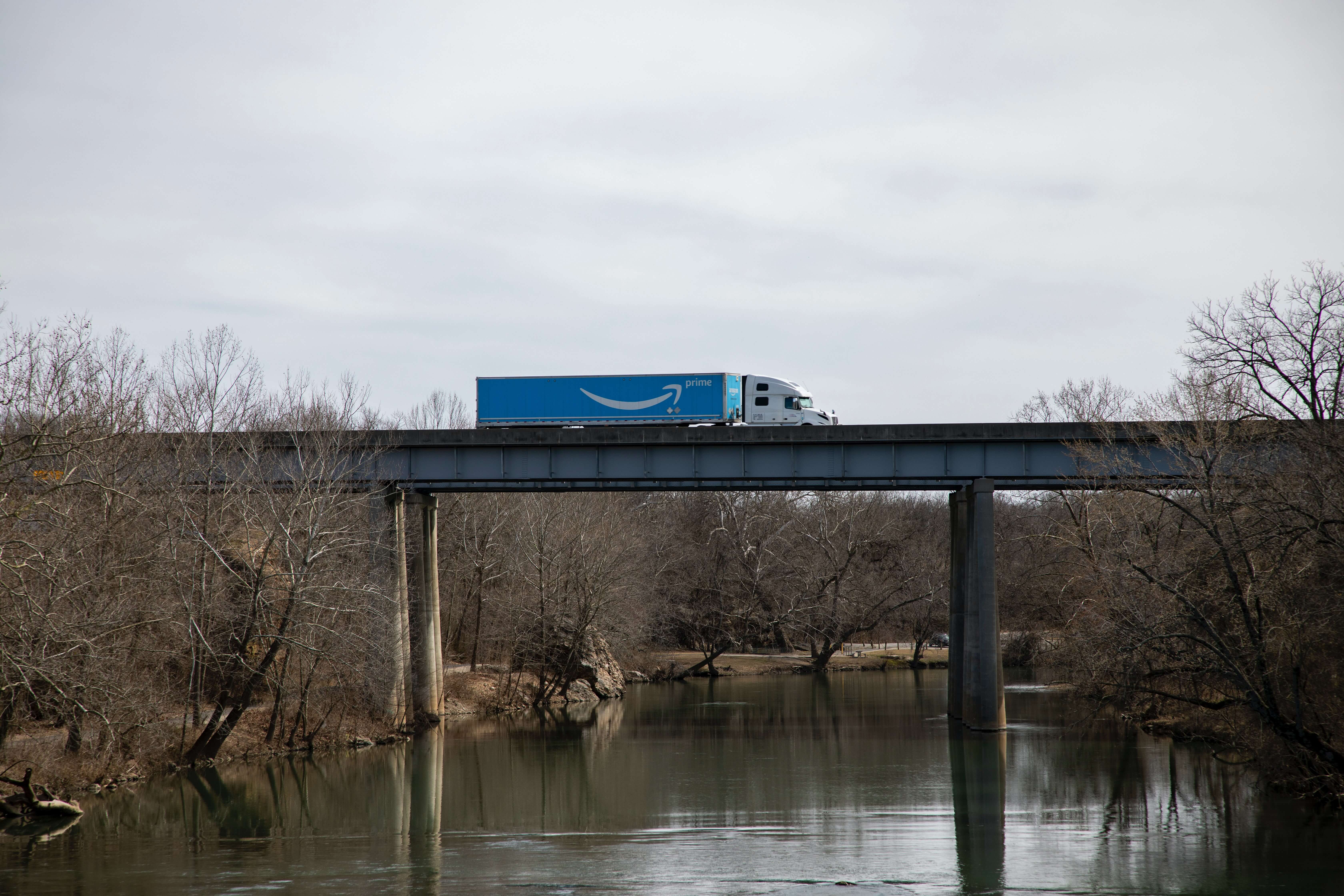 An Amazon truck drives over a bridge.