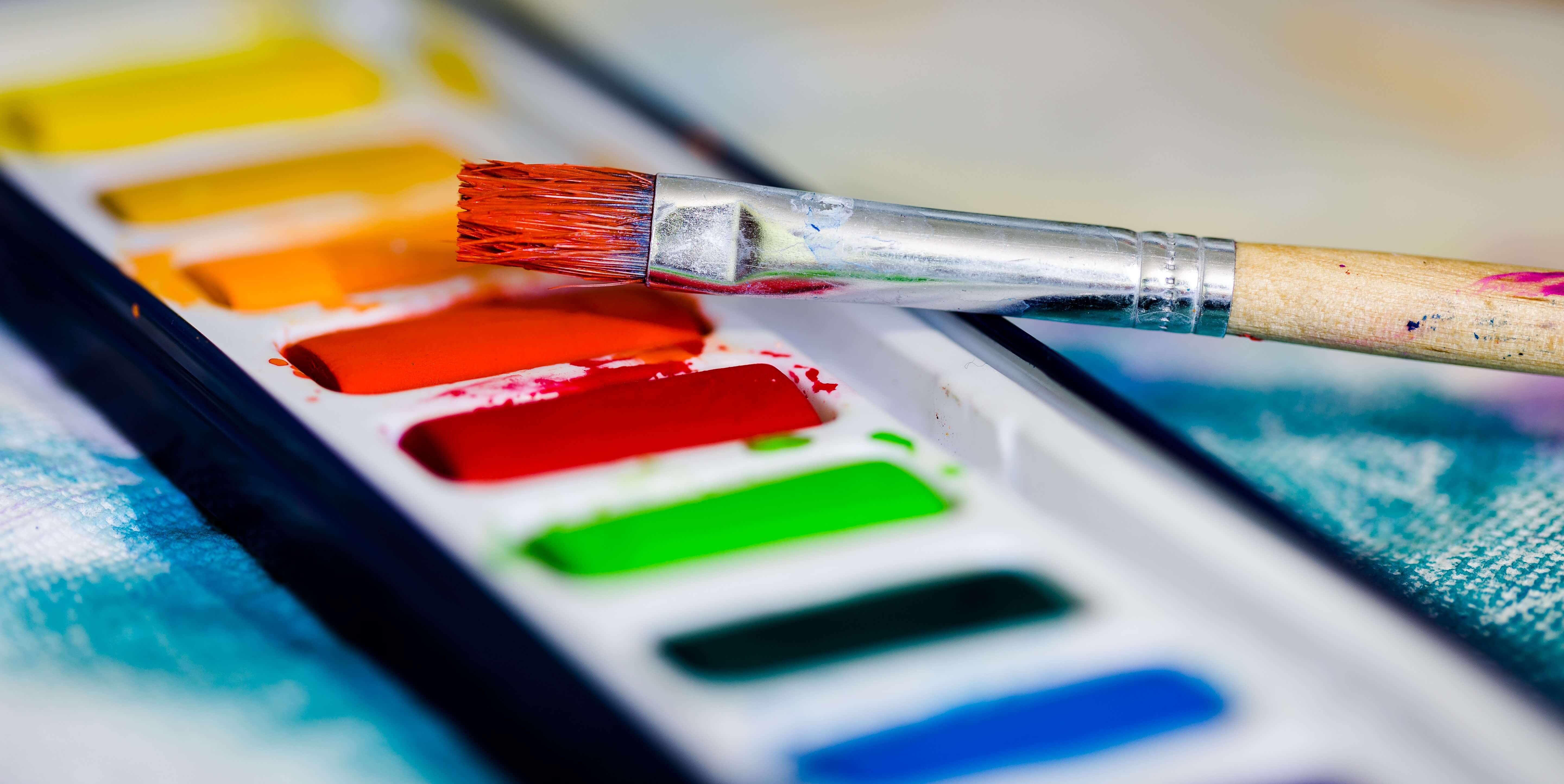 A paintbrush resting on a watercolor pallette