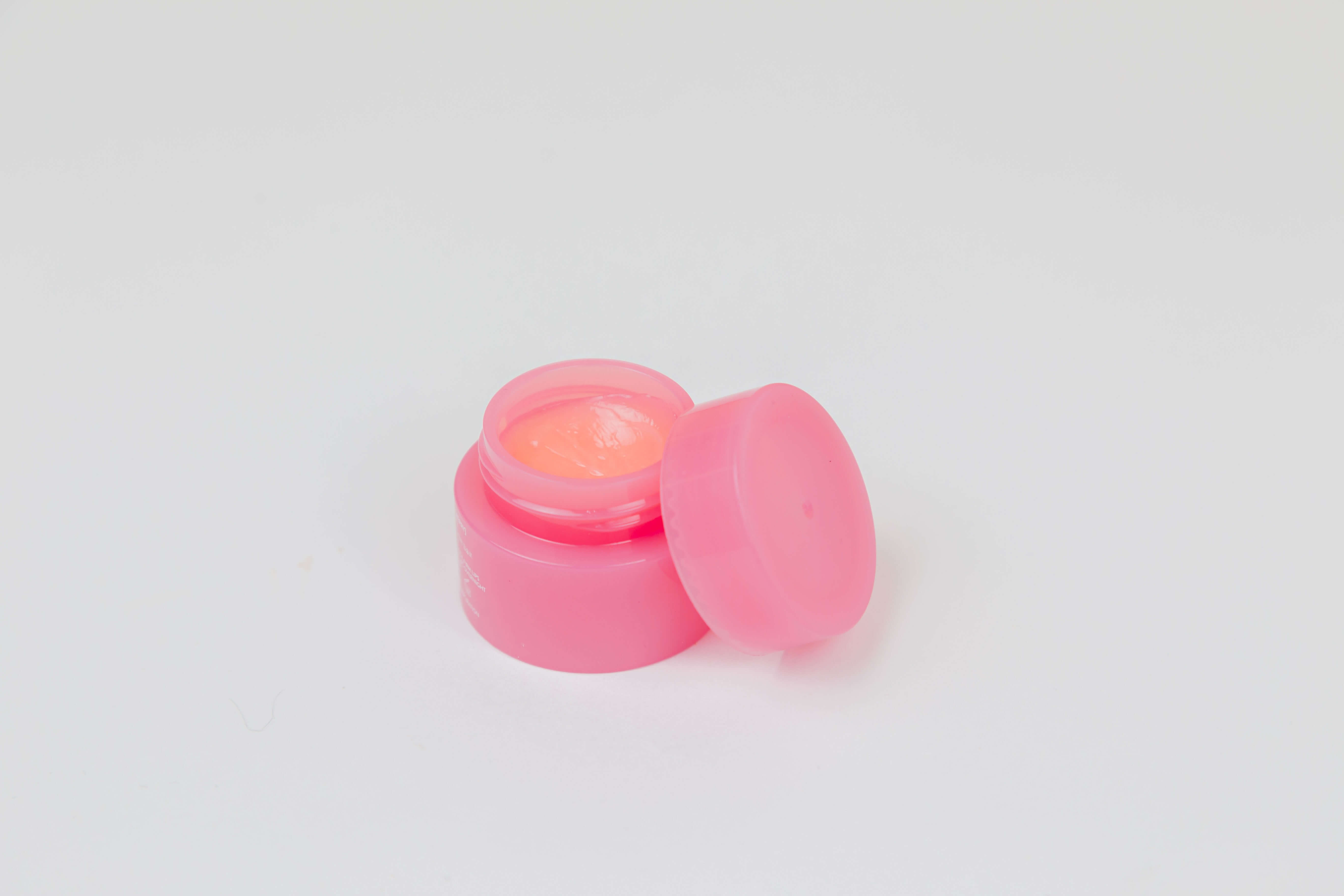 A small pink jar of lip balm