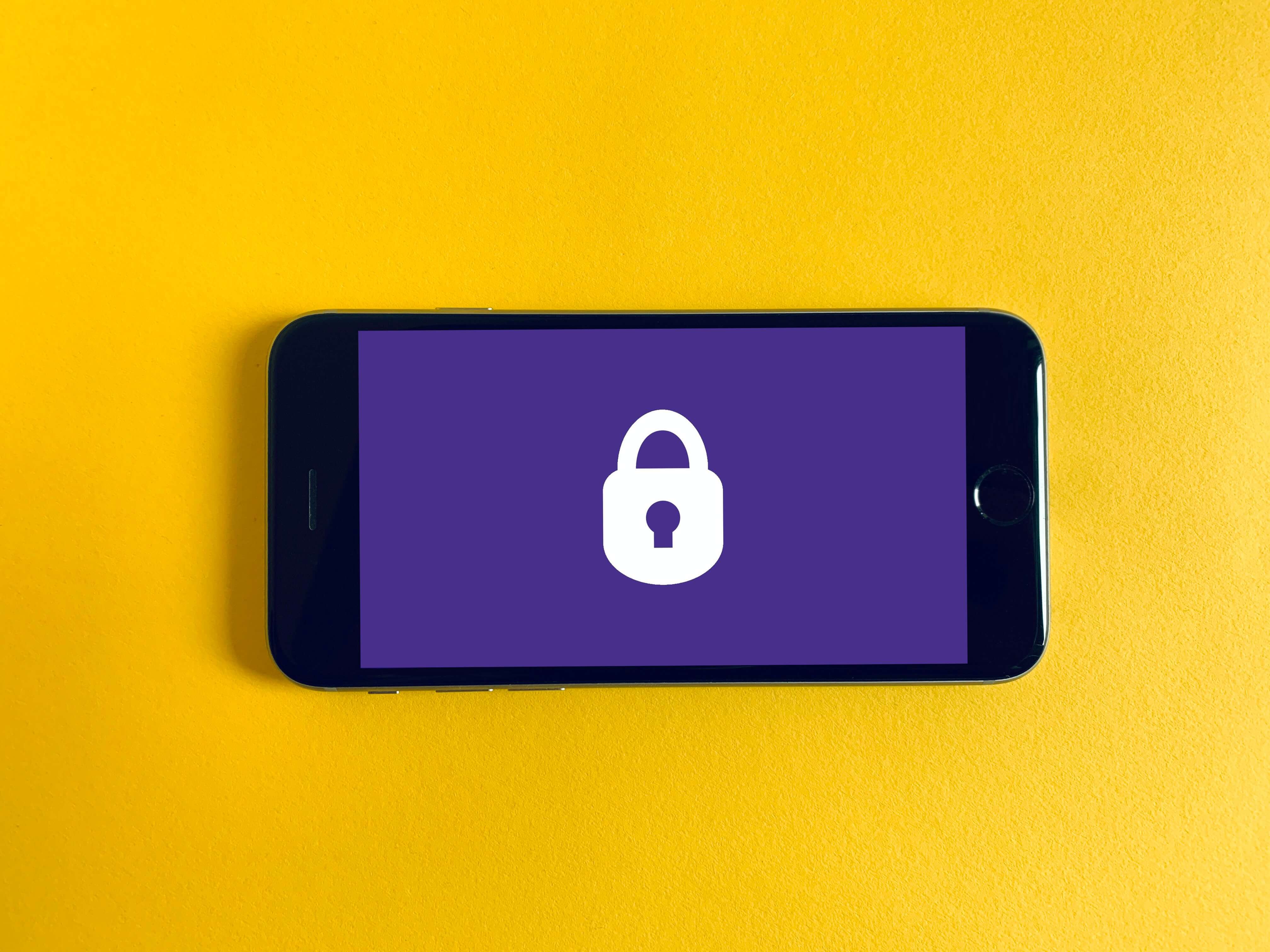 A smartphone displaying a white padlock icon against a purple background