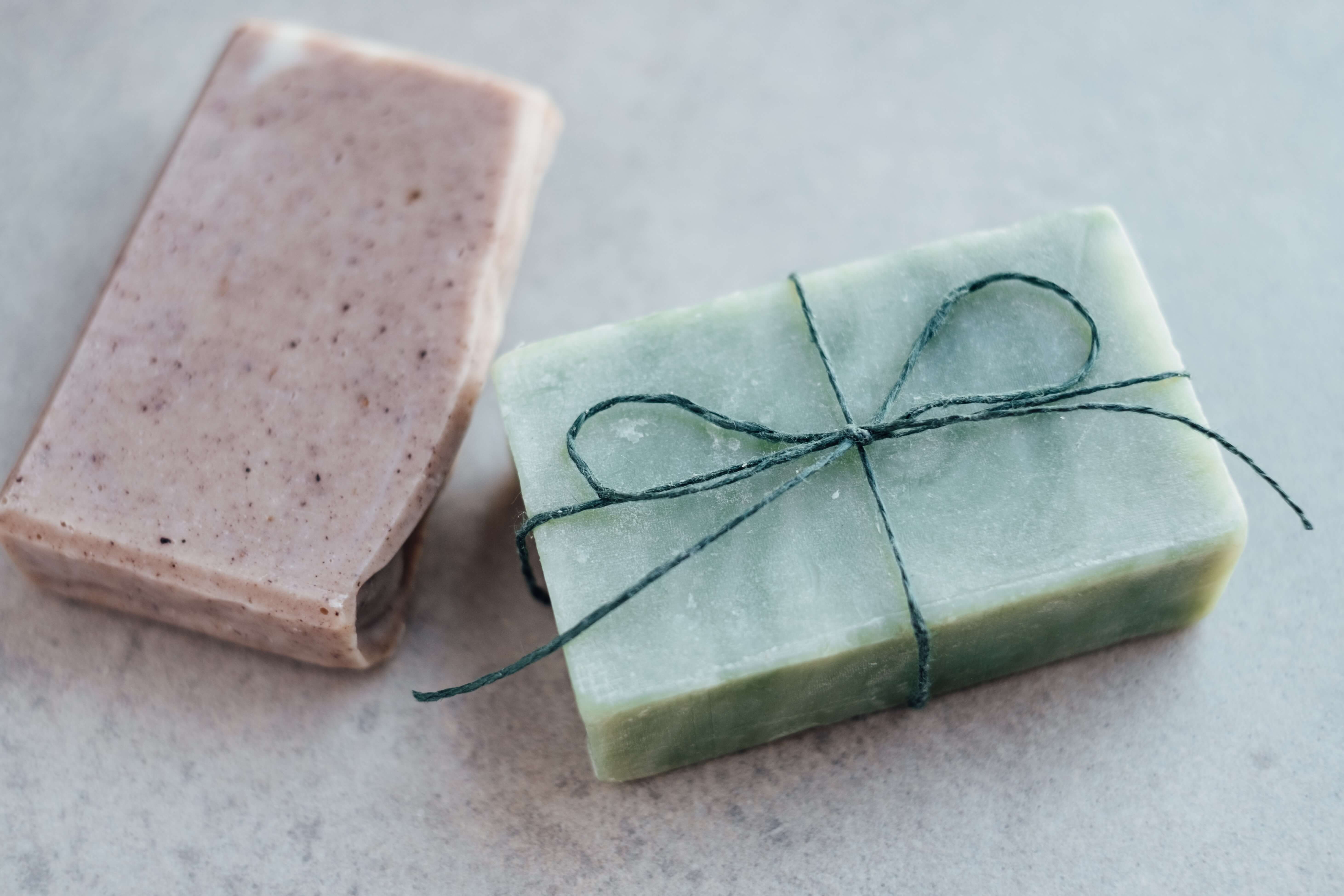 Two bars of homemade soap: one pink and one green