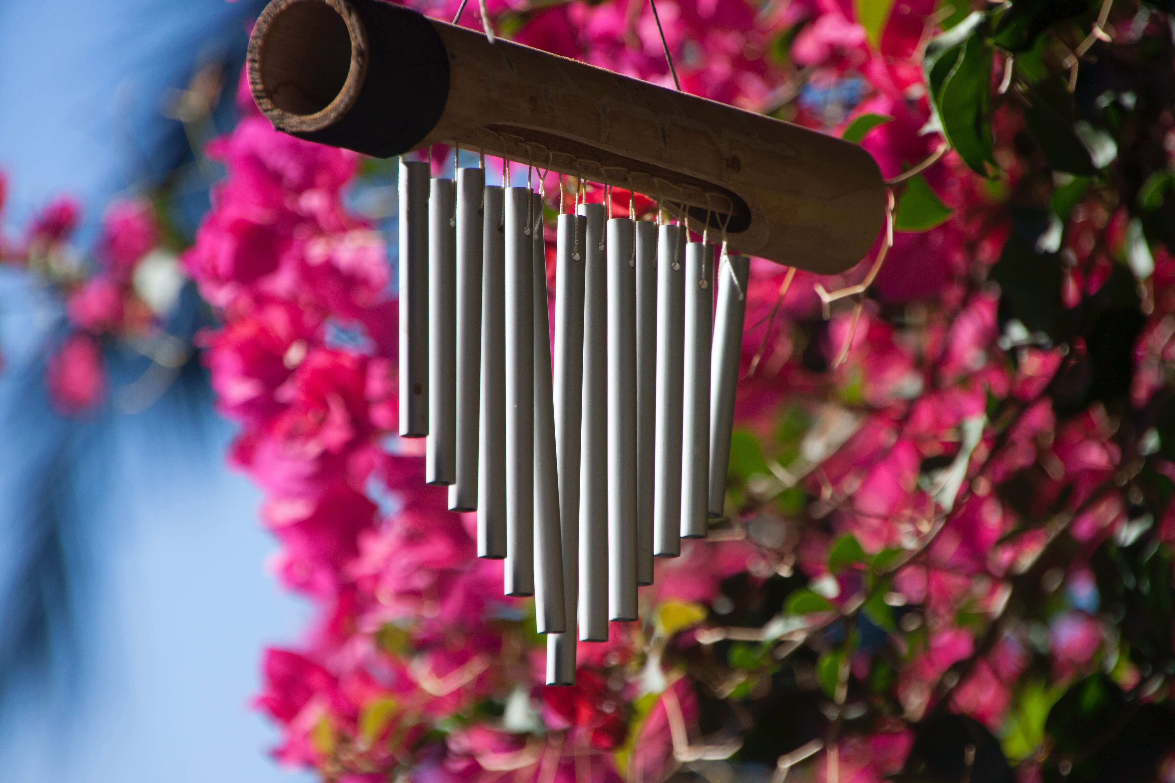 A wind chime with the chimes hanging from a wooden tube
