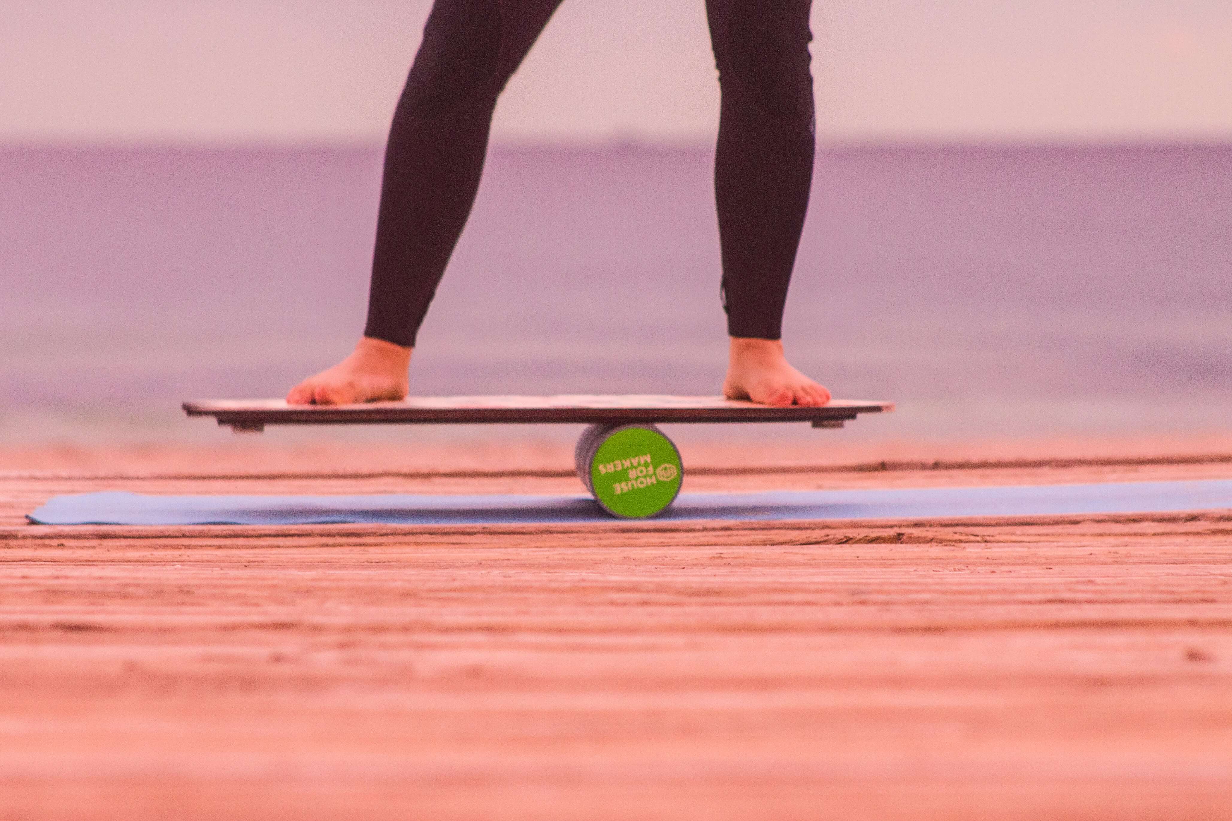 A closeup of a barefoot person on a balance board