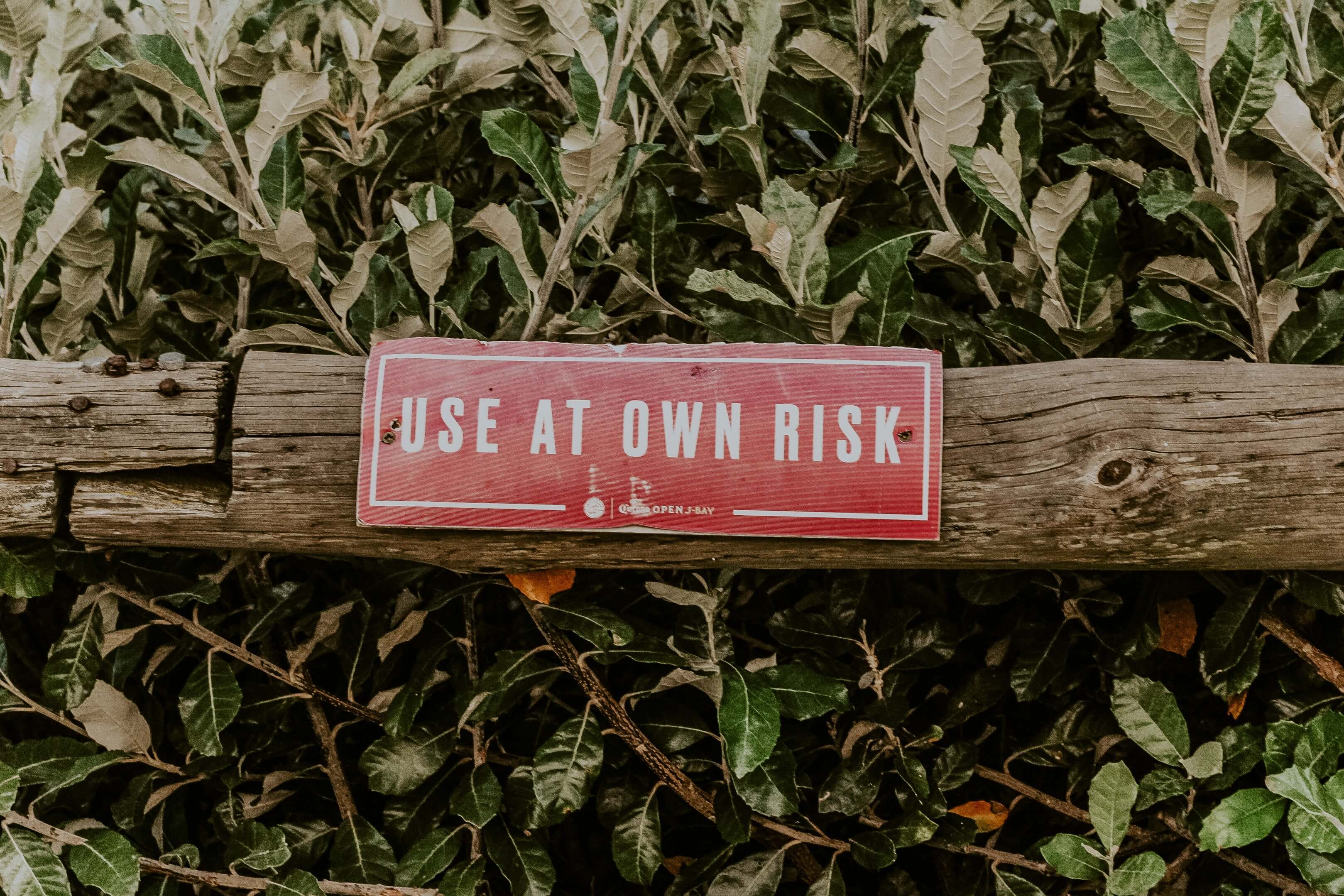 A sign on a fencepost that reads "use at your own risk"