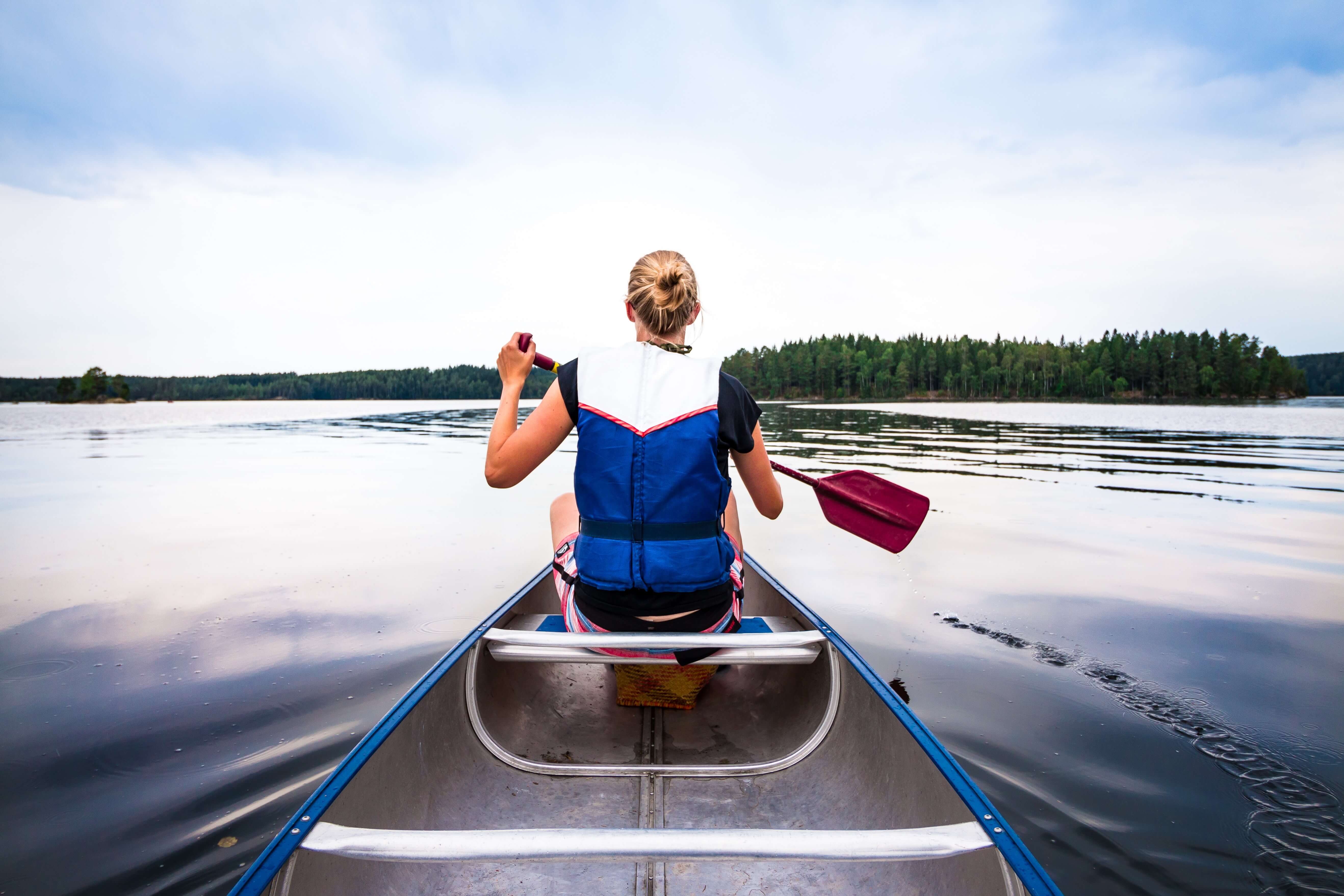 A woman kayaking photographed from behind