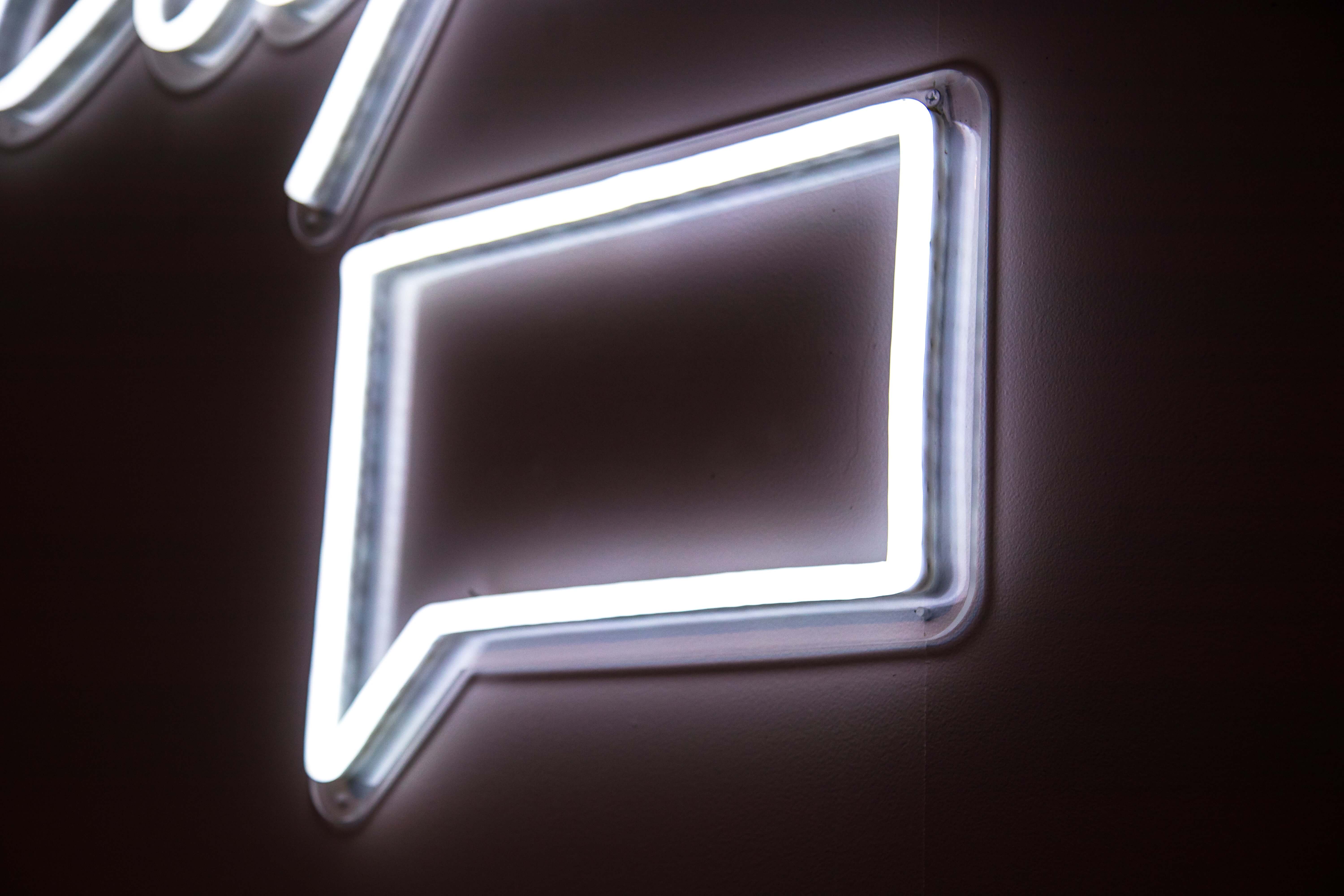 A neon sign shaped like a squared off speech bubble