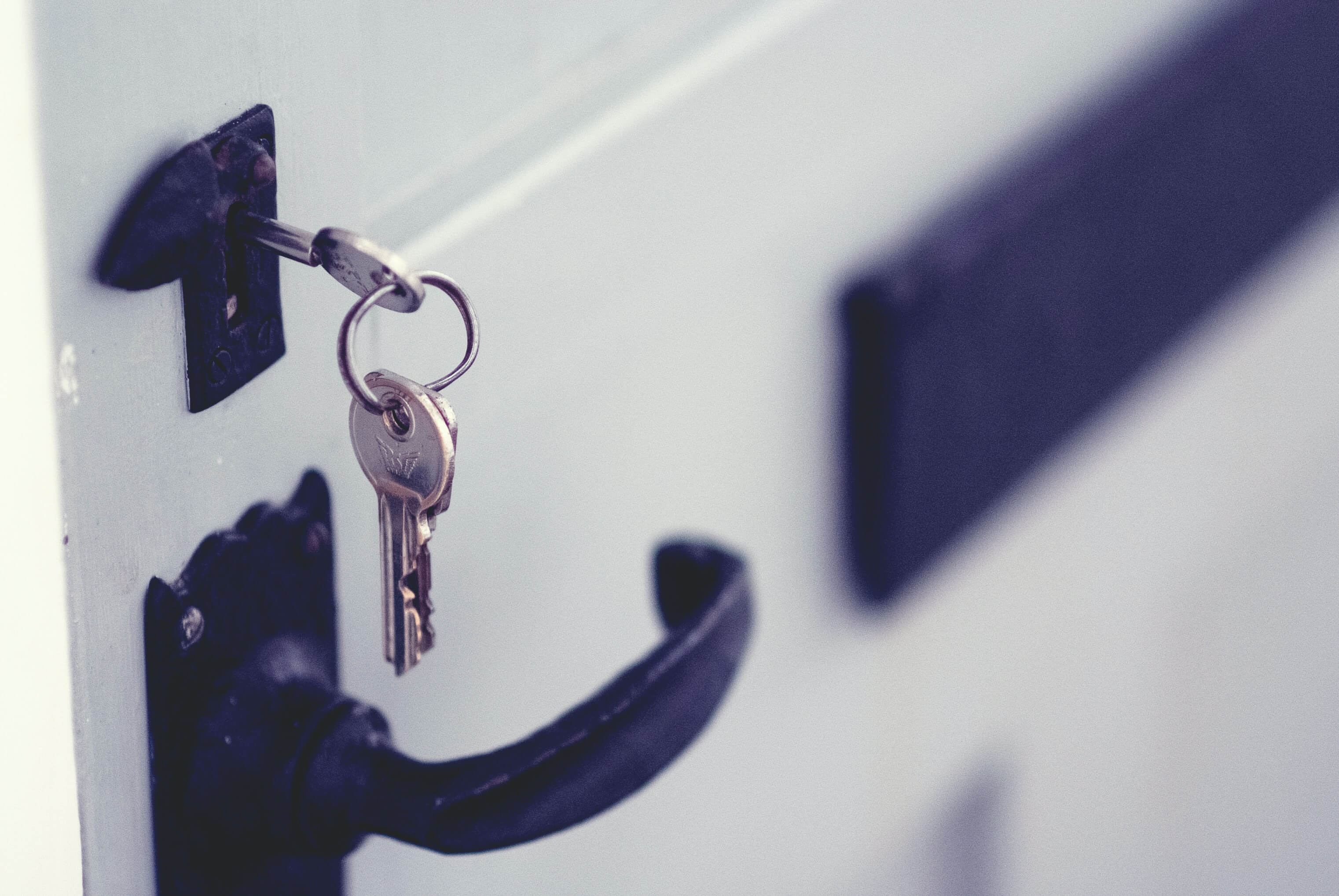 A silver key unlocking a door