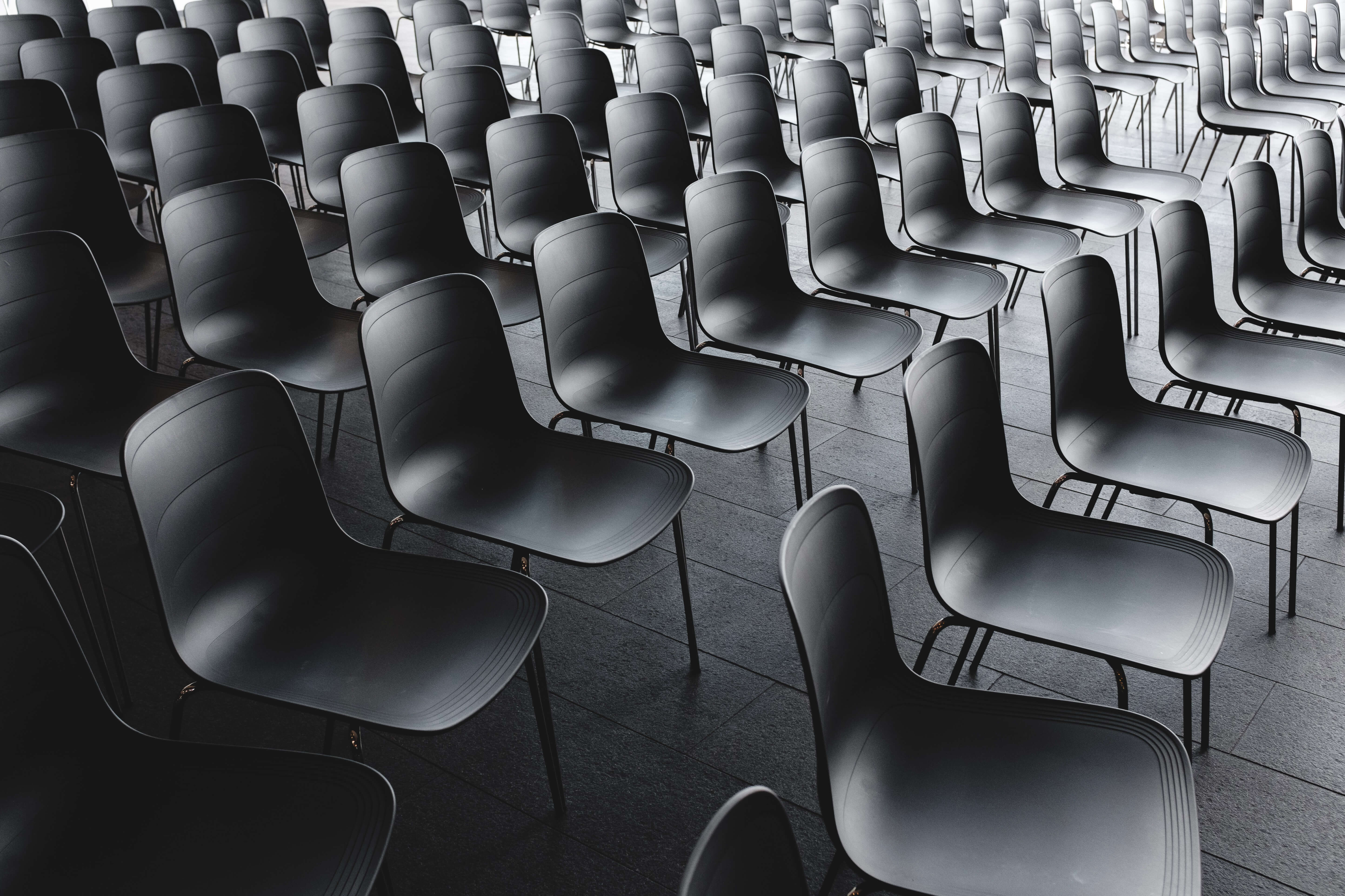A black and white photo of rows of classroom-style chairs