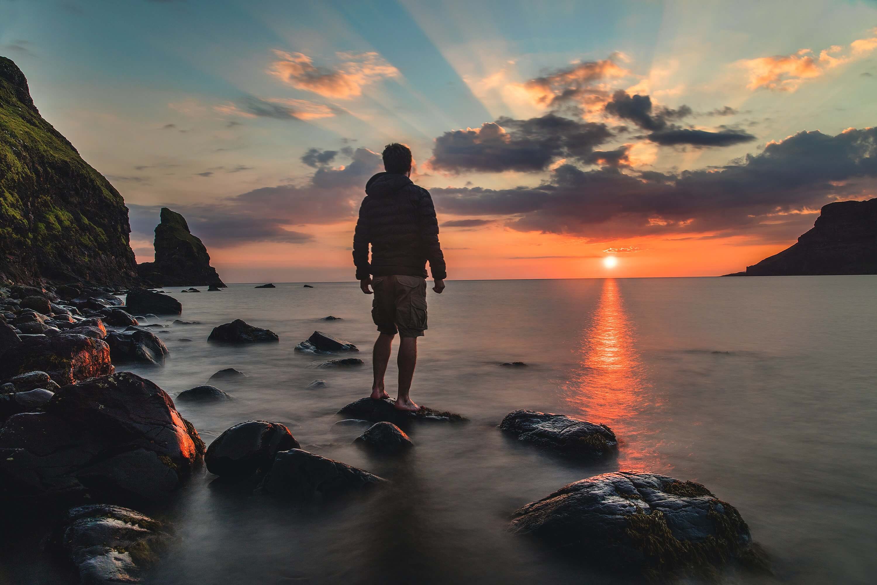 A man admires the sunset on a beach