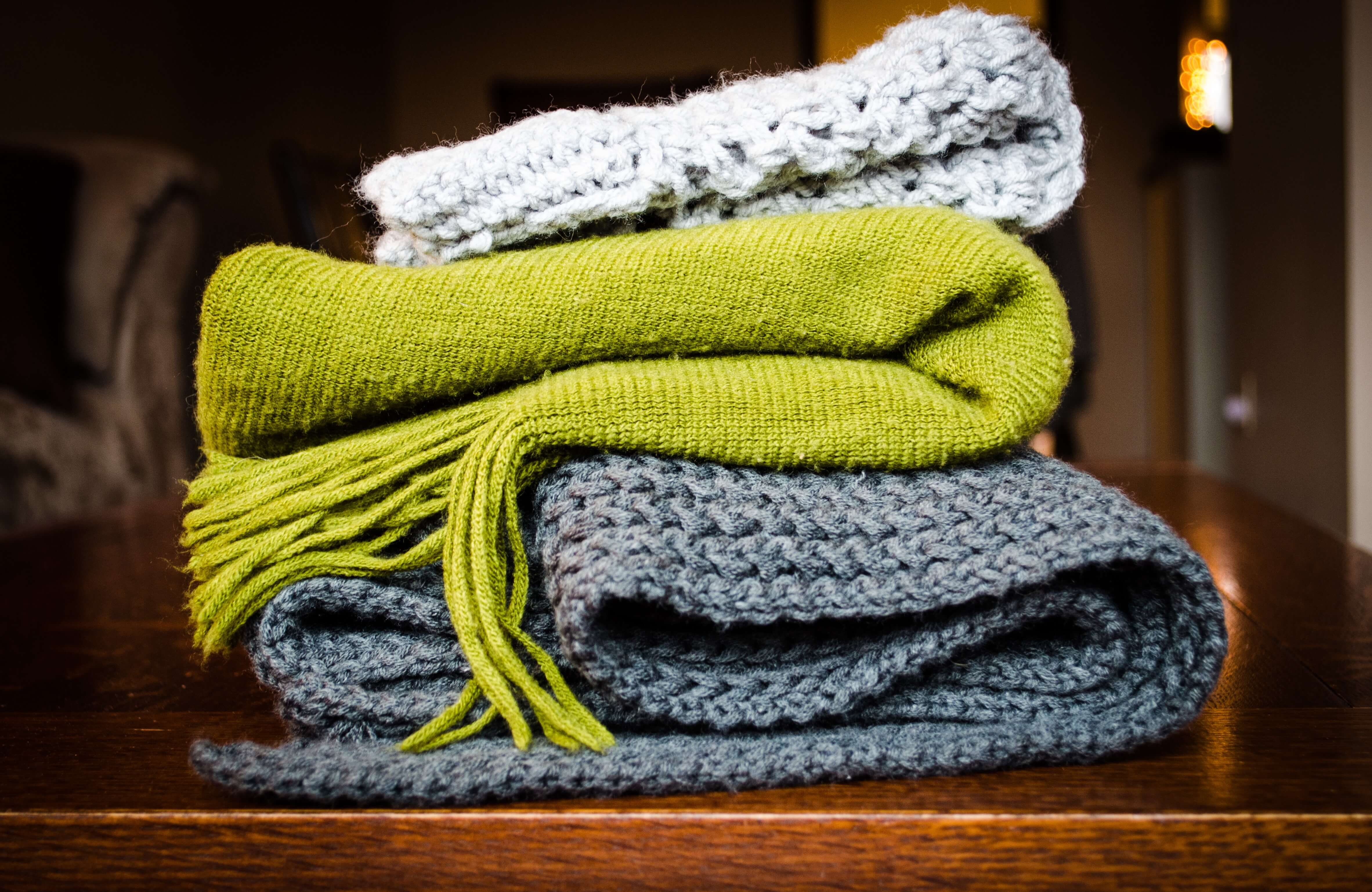 Three knitted scarves folded up.
