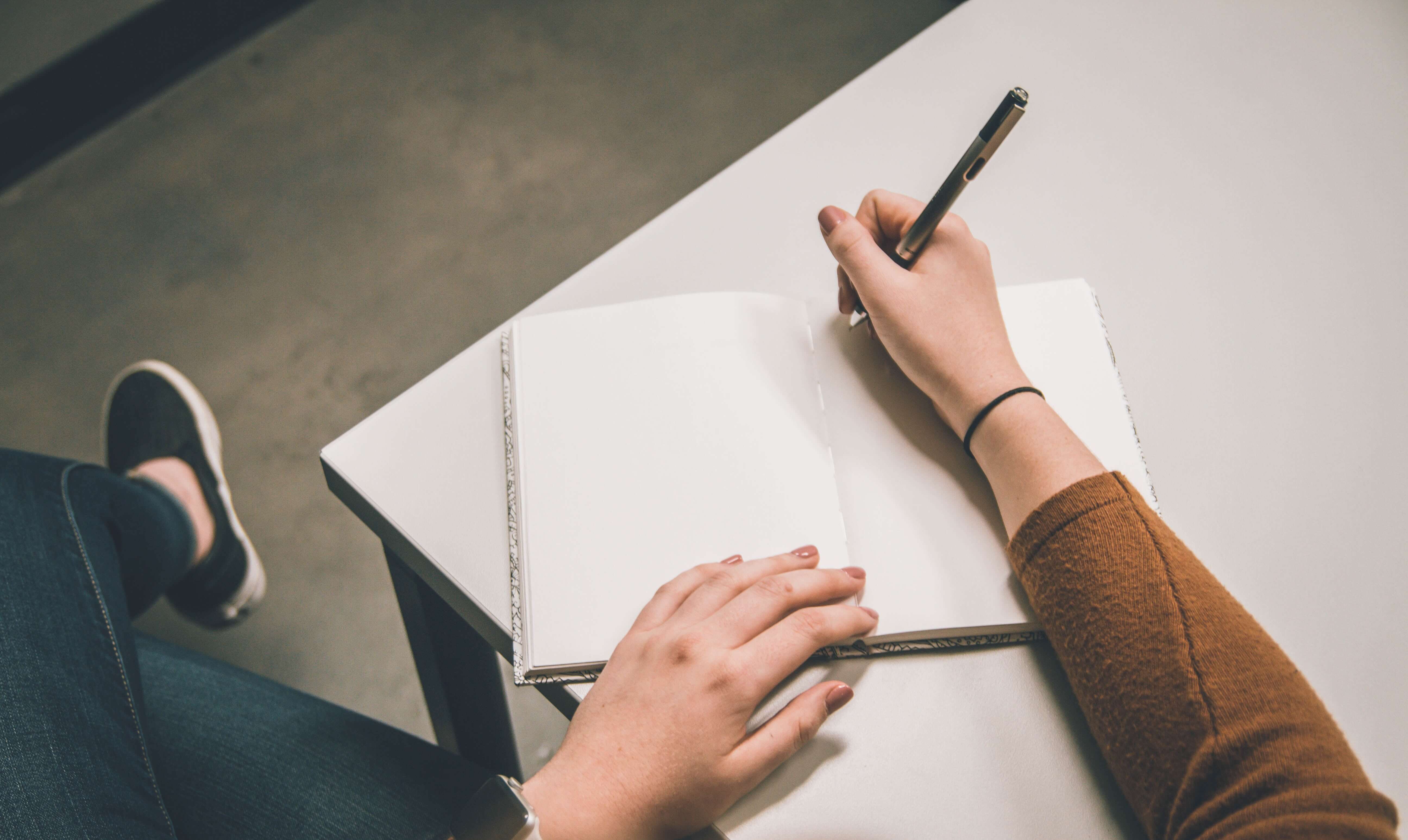 A person writing in a notebook