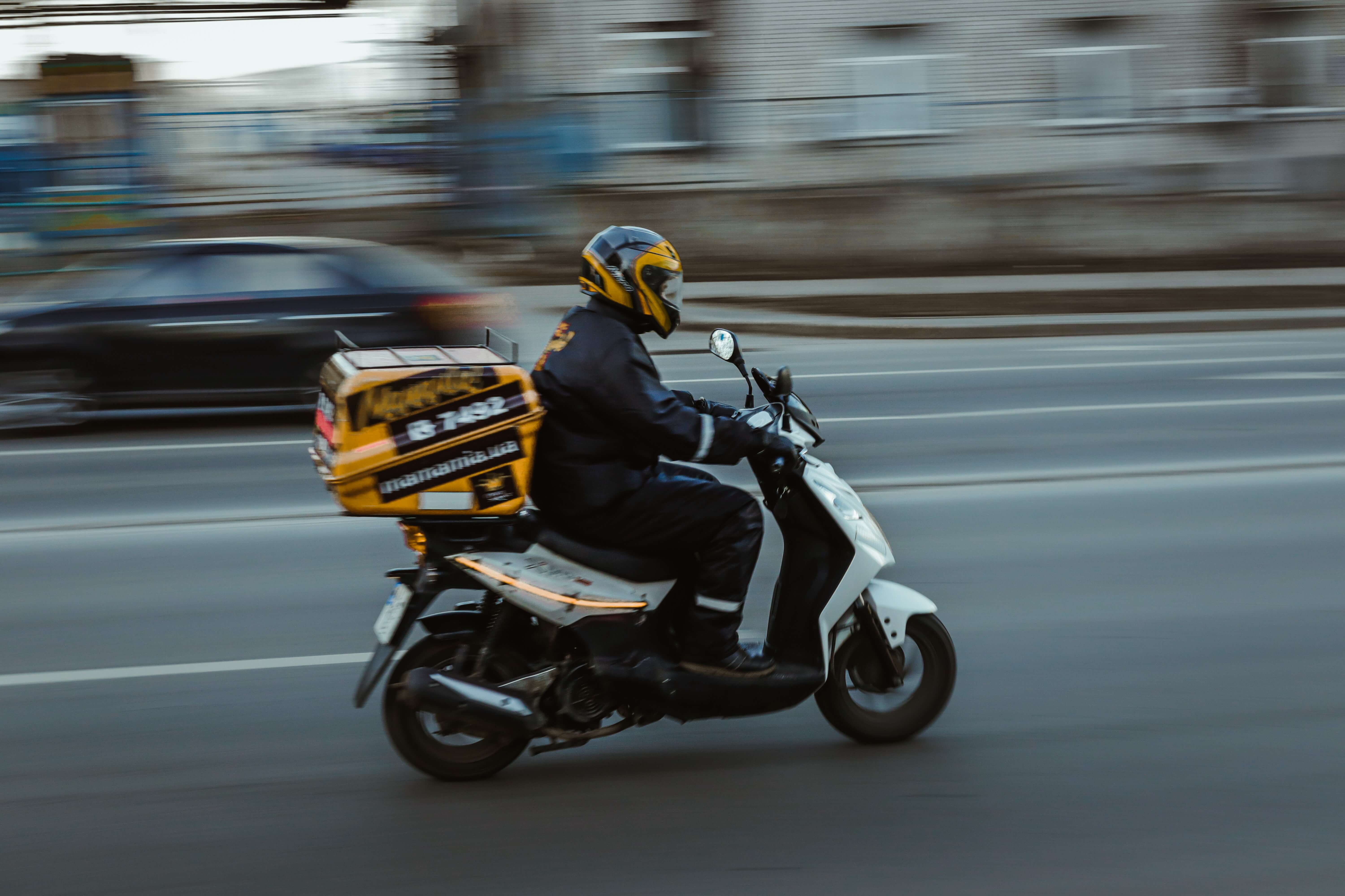 A delivery driver on a motorcycle