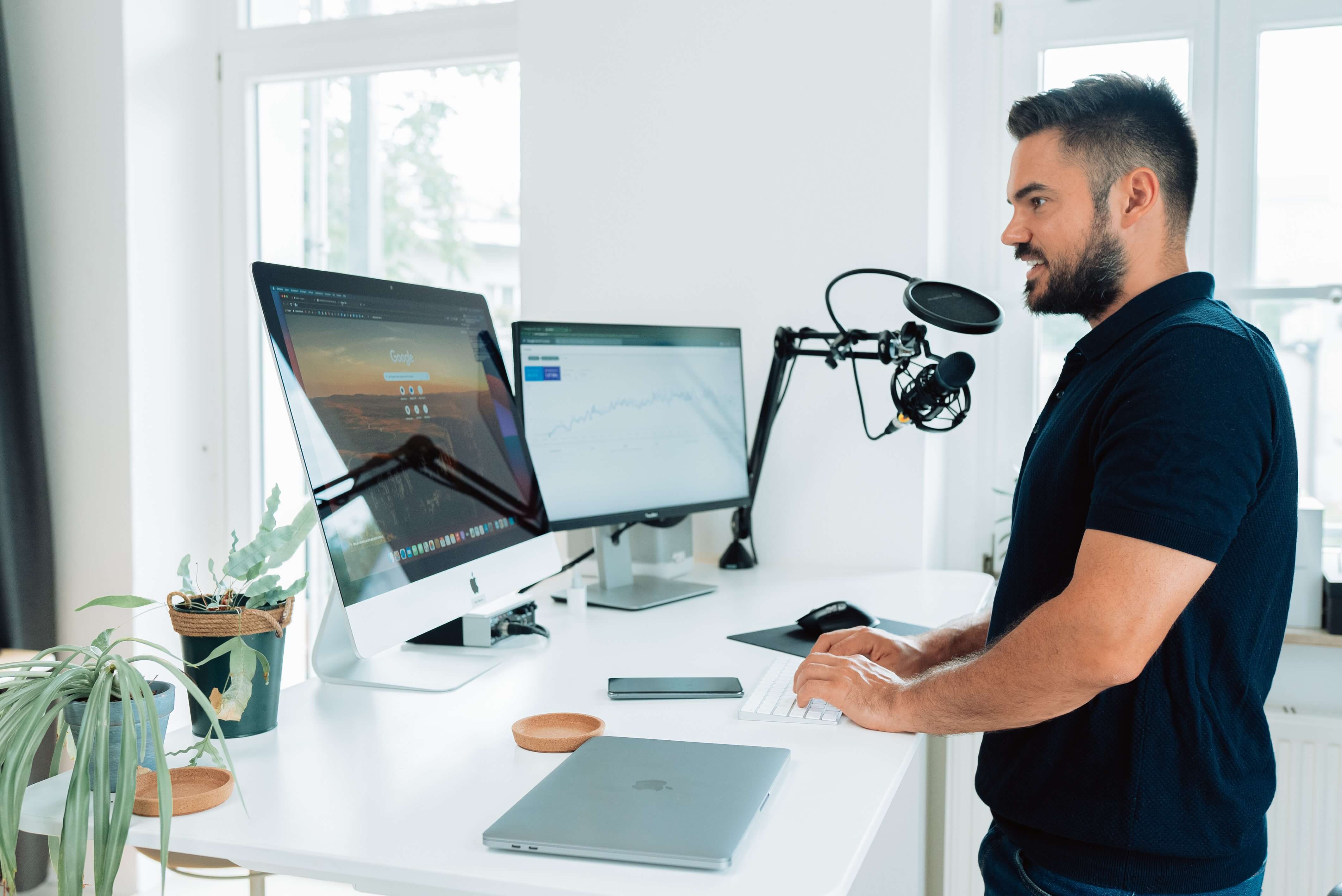 A latino man recording audio into a microphone