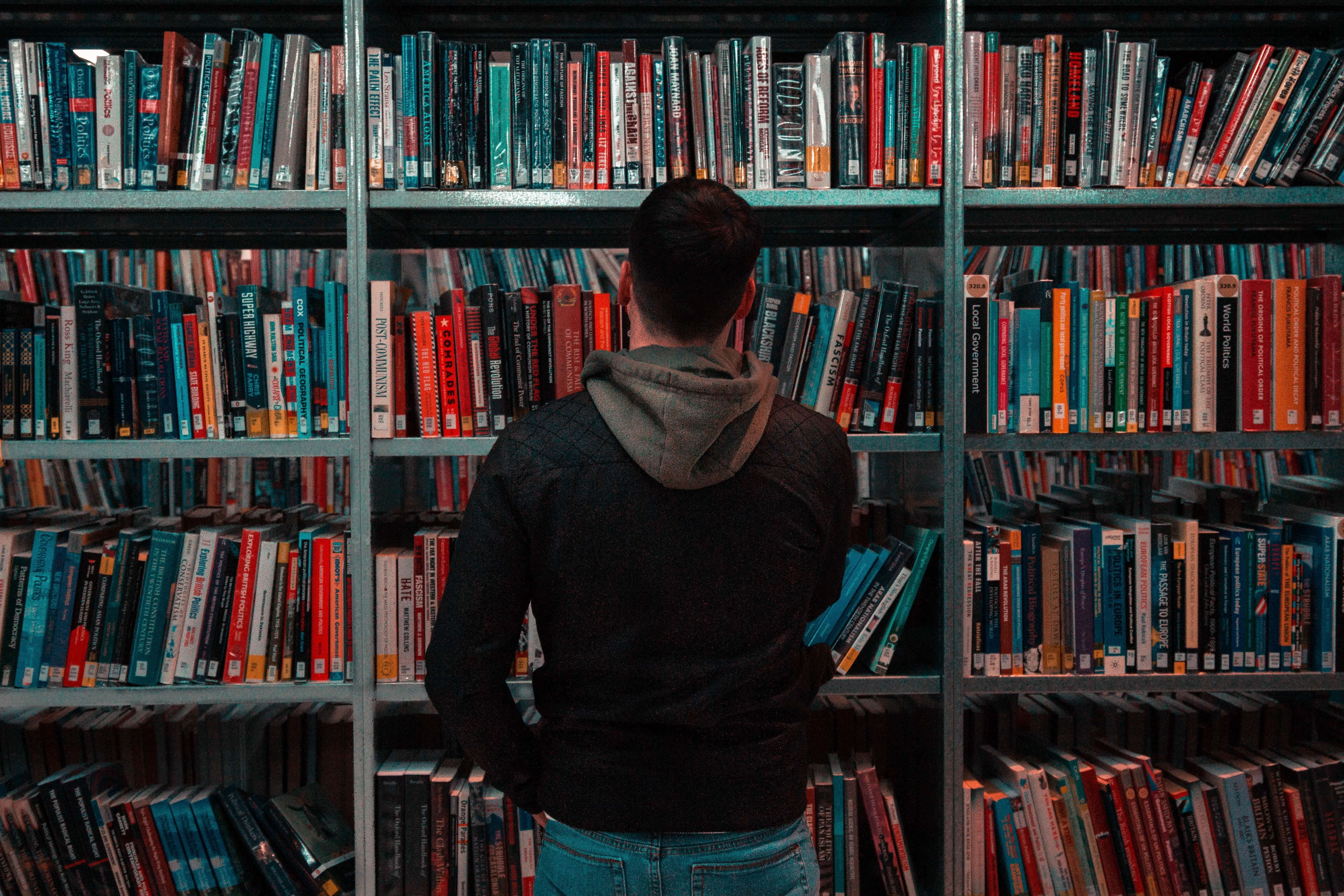 A person browsing a shelf at a library