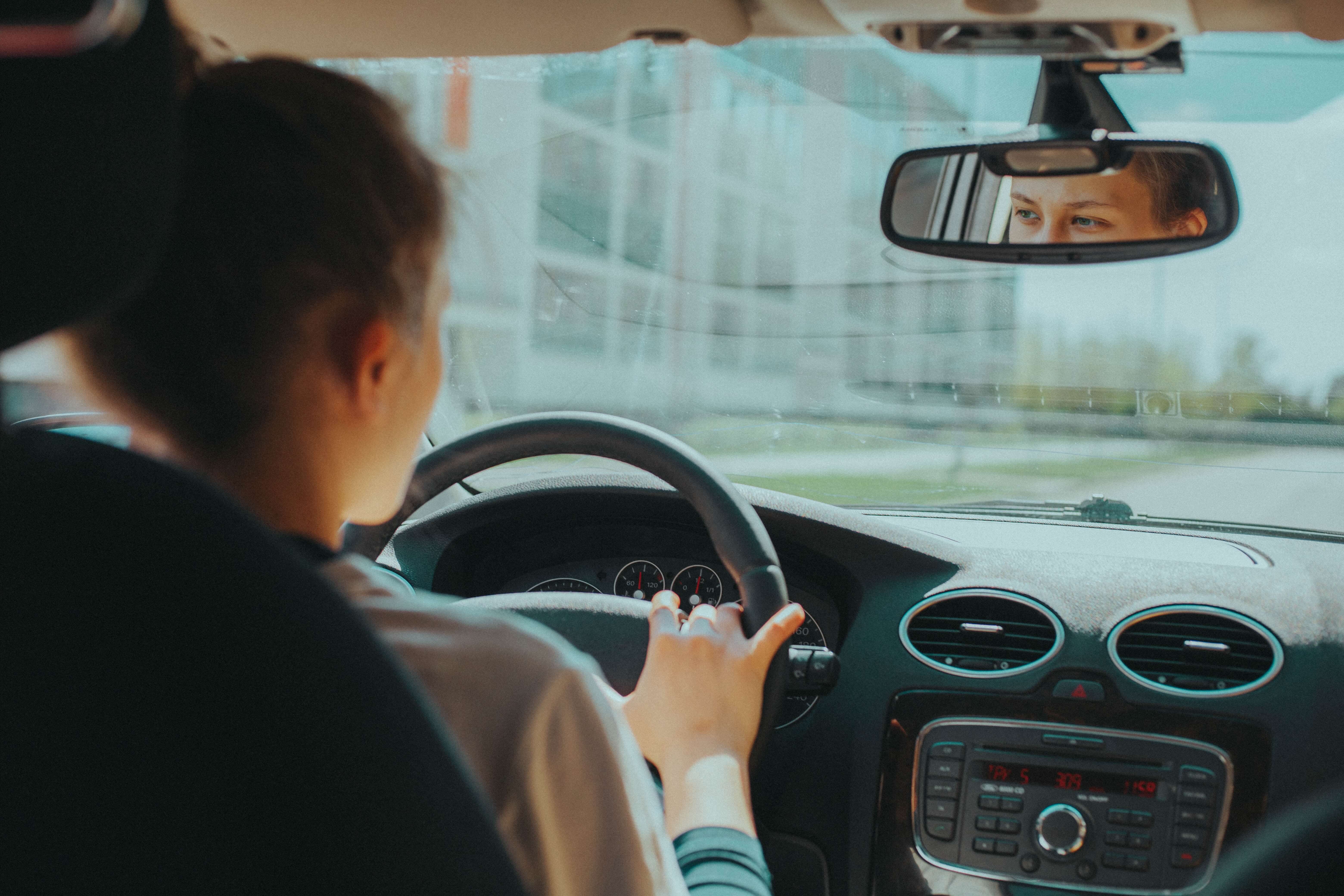 An interior shot of a white woman driving a car