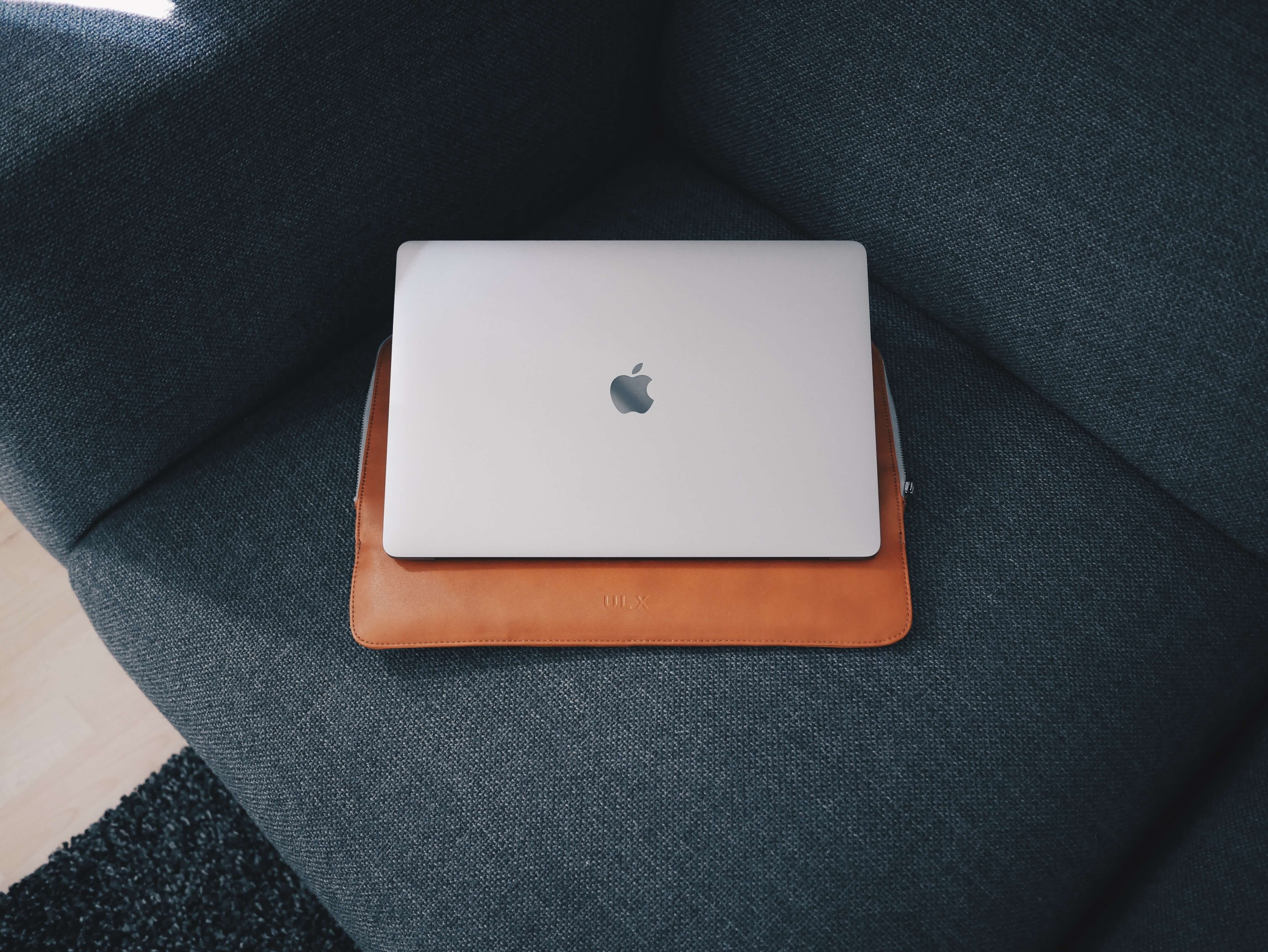 A Macbook with a leather carrying case