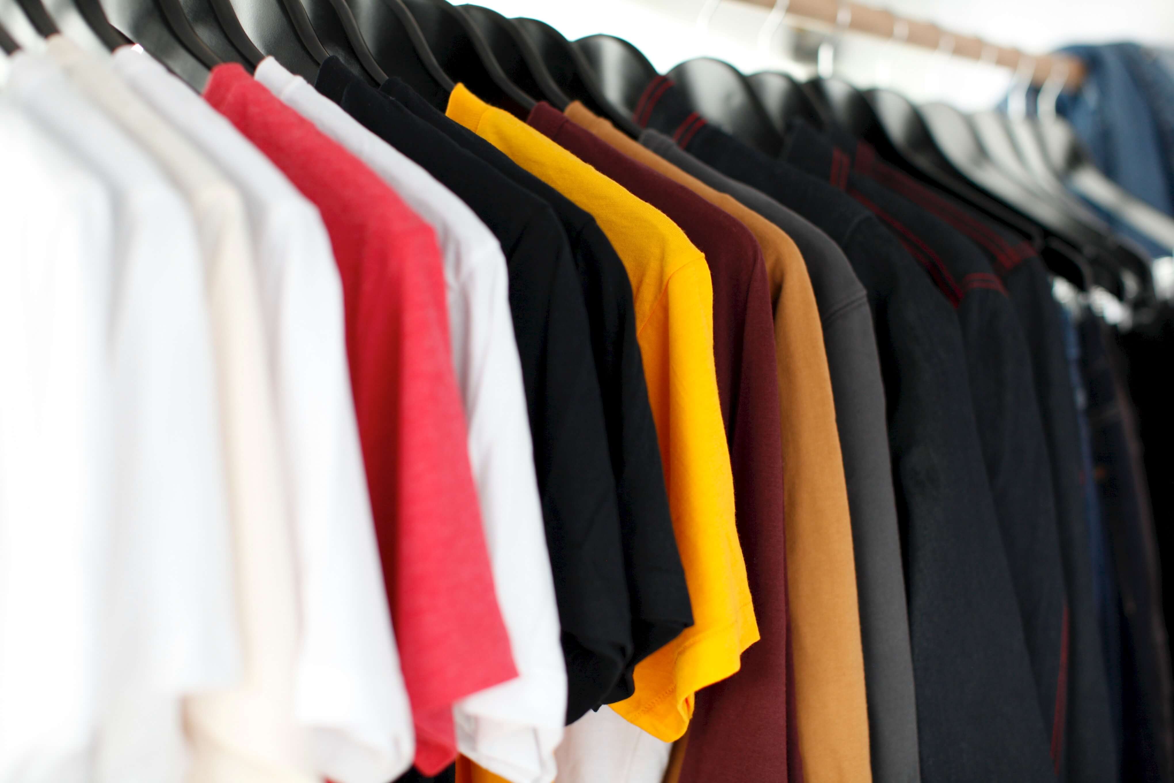 Various solid-colored T-shirts on a rack