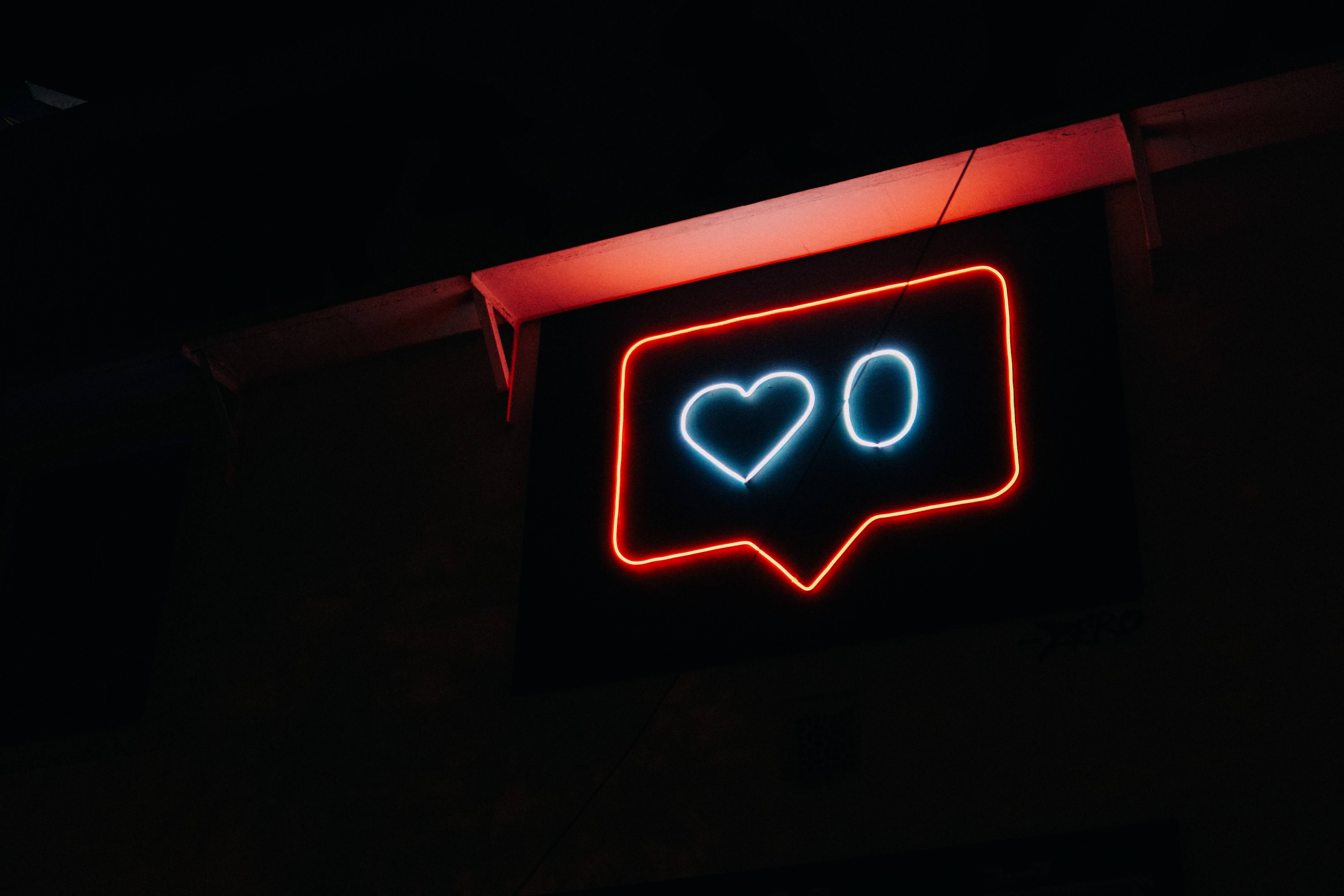 A neon sign depicting an Instagram like notification 