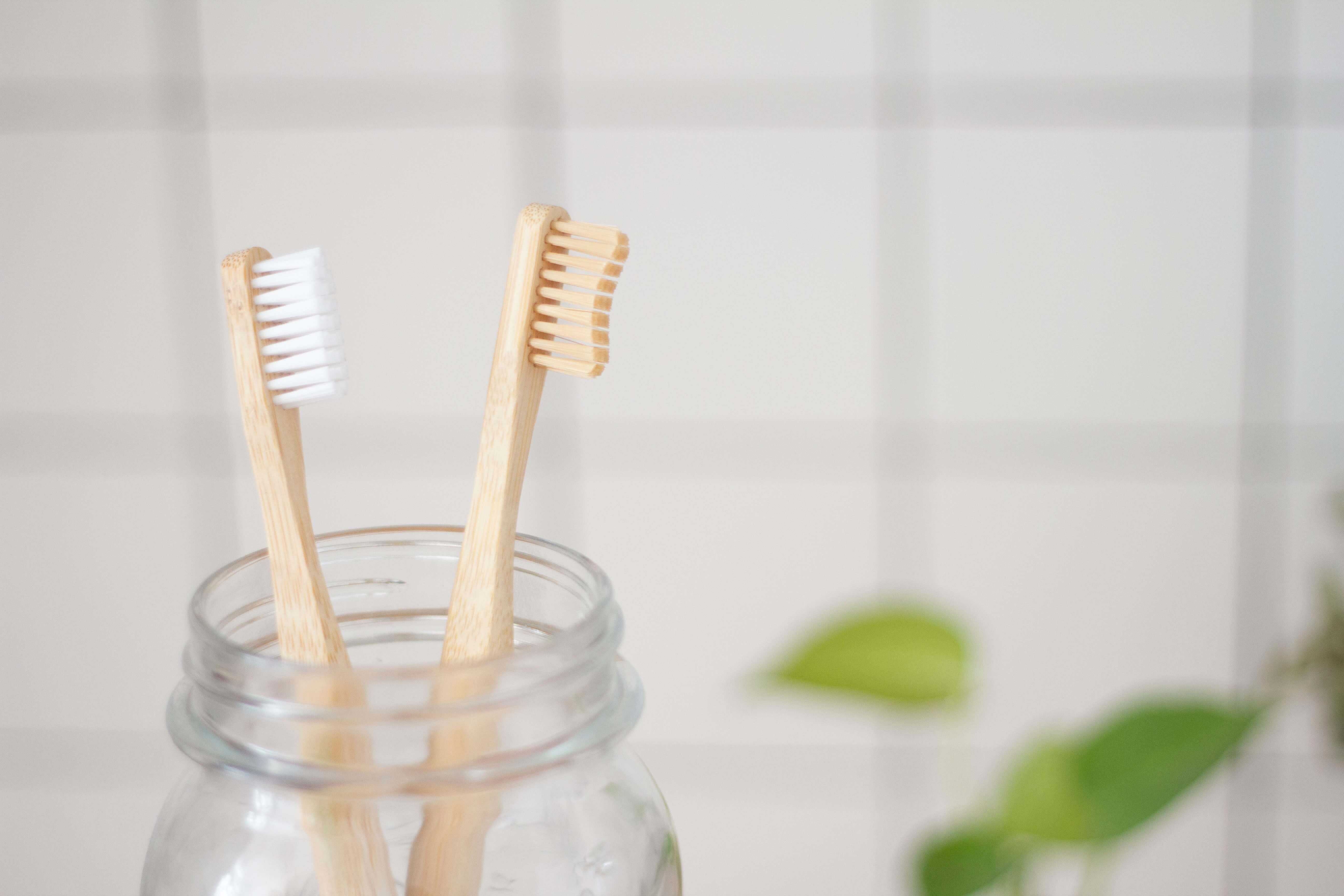 Two bamboo toothbrushes in a mason jar