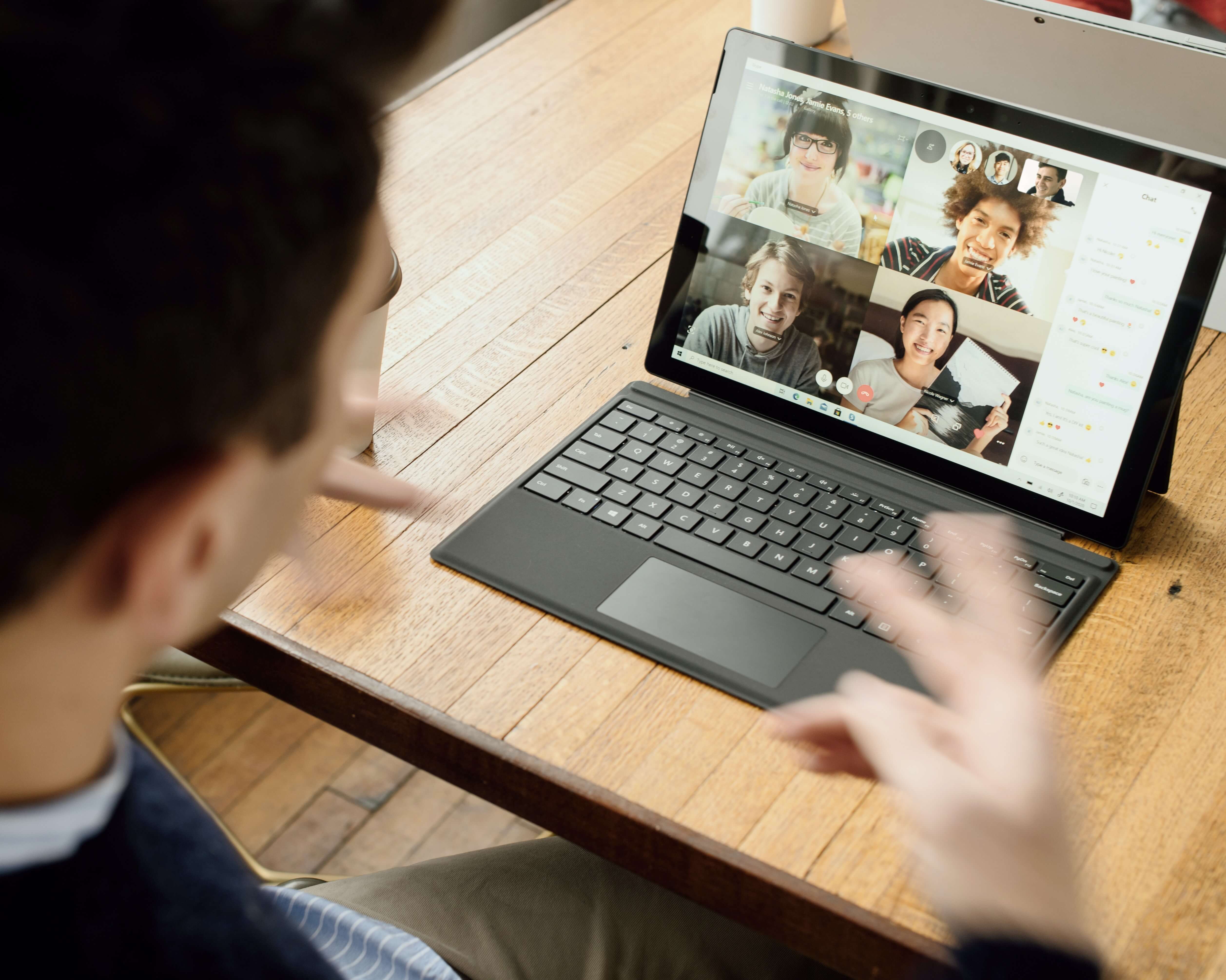 A person on a video call with four participants on the screen