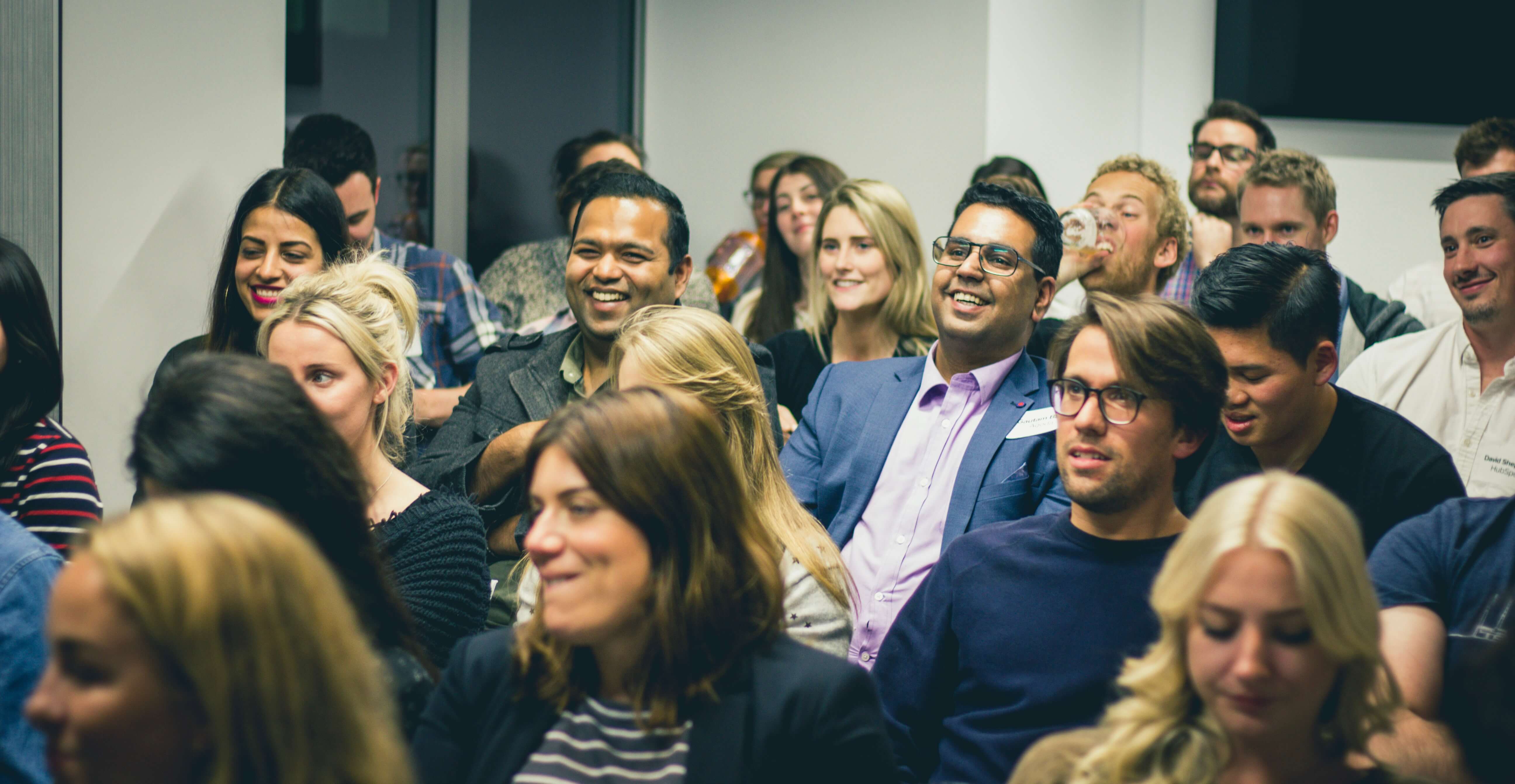 A diverse group of people in business casual clothing watching a presentation