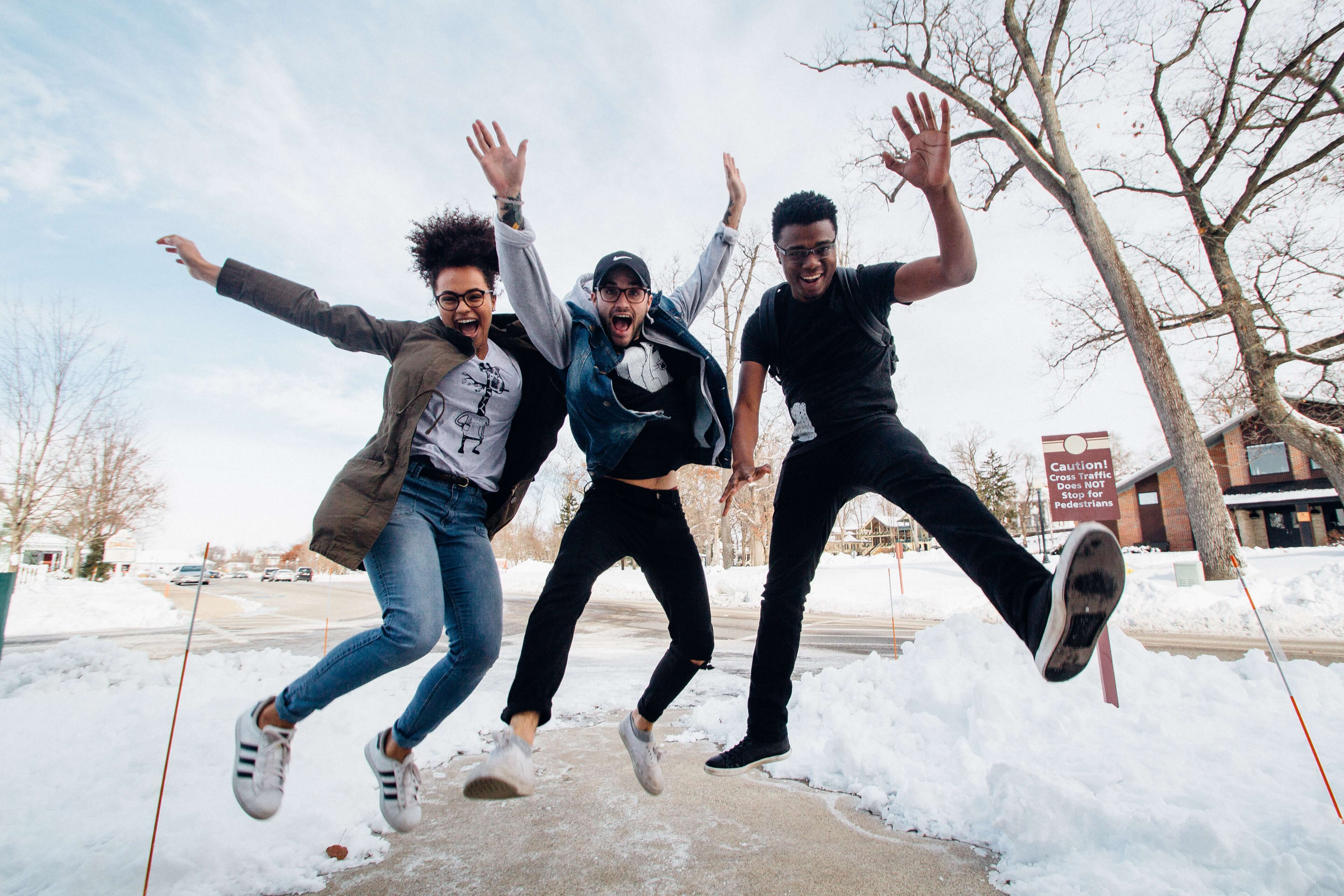 Three young adults jumping into the air