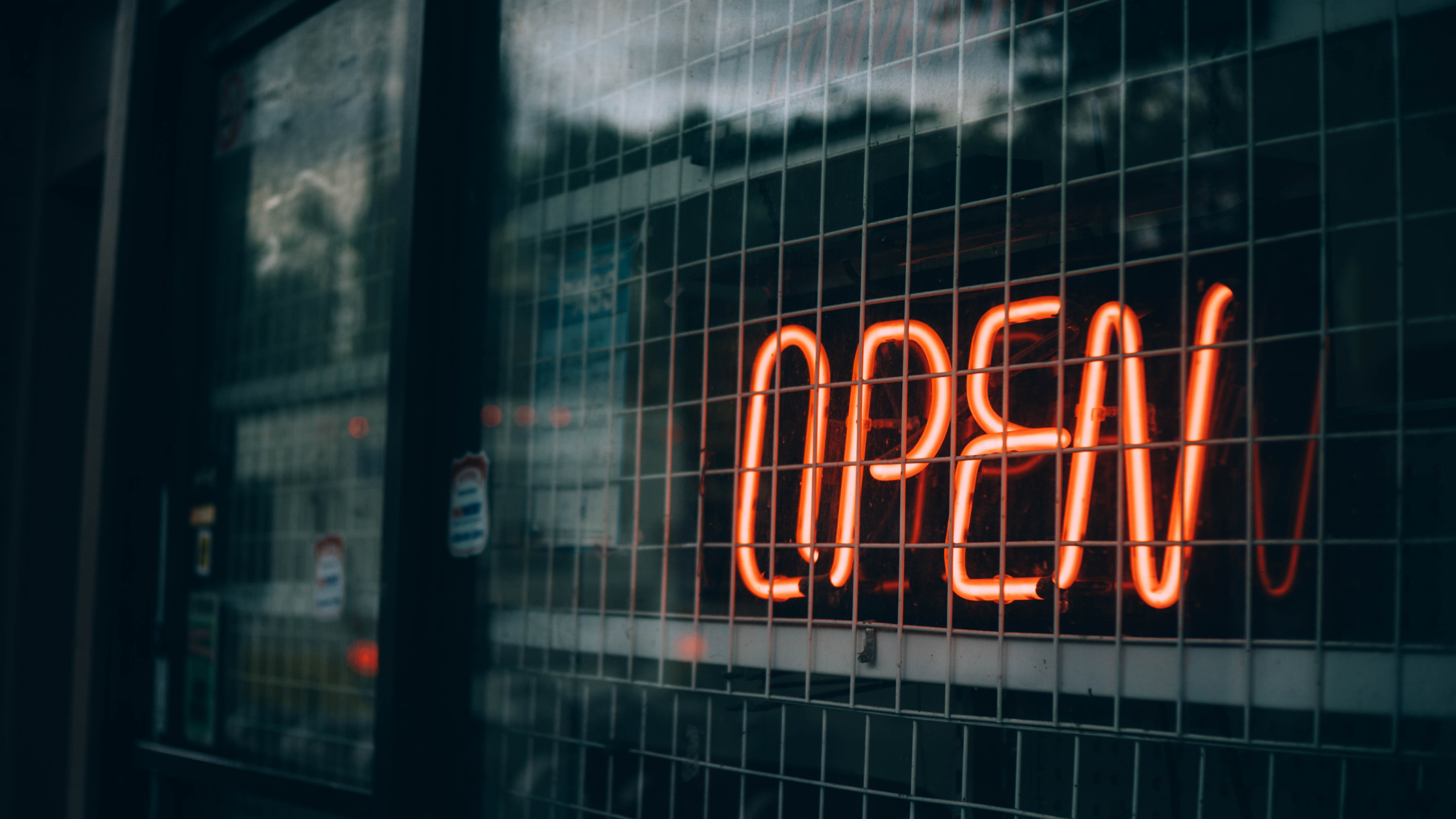 A neon sign that reads "open" in a shop window