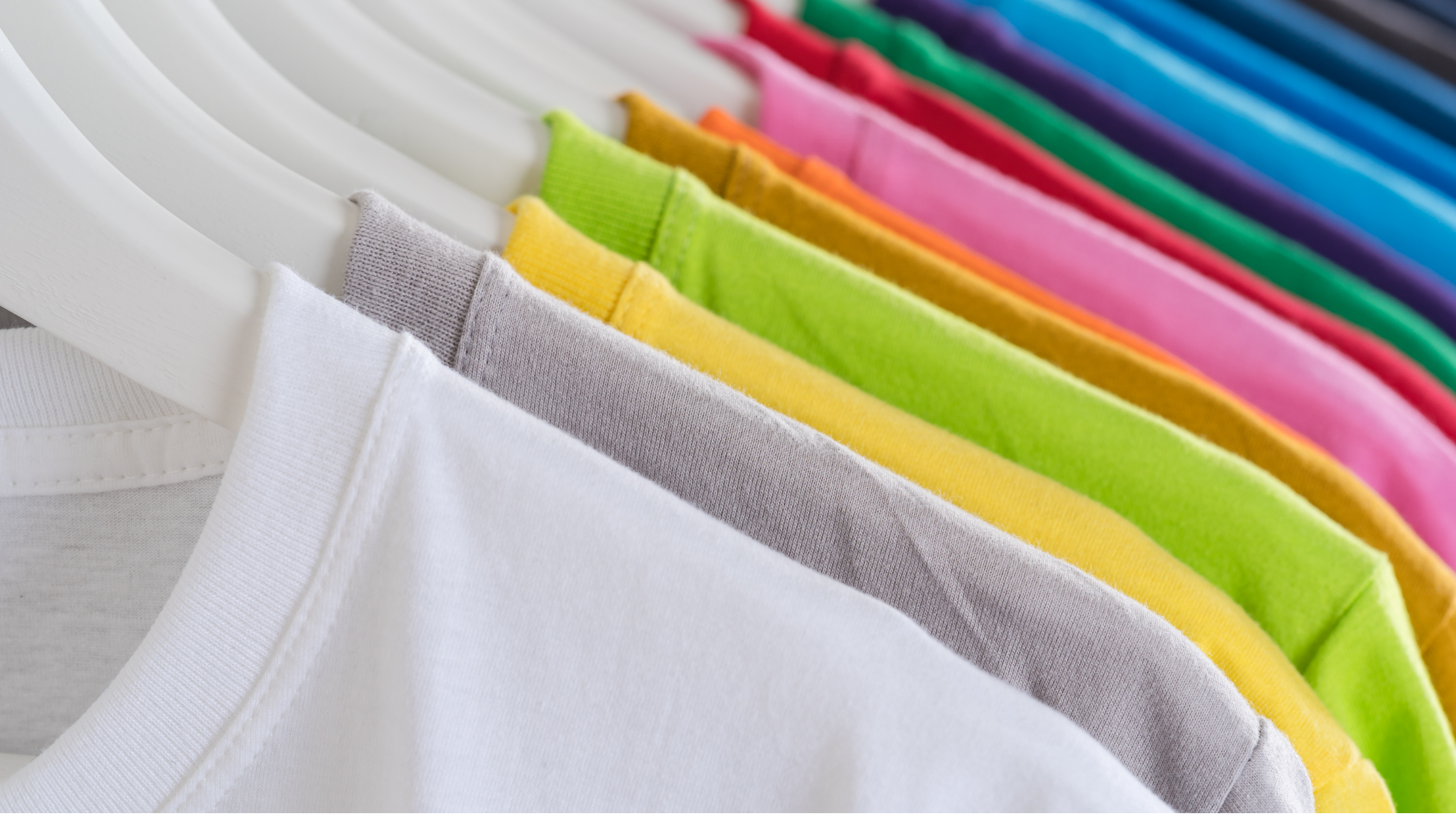 A rack of different colored T-shirts